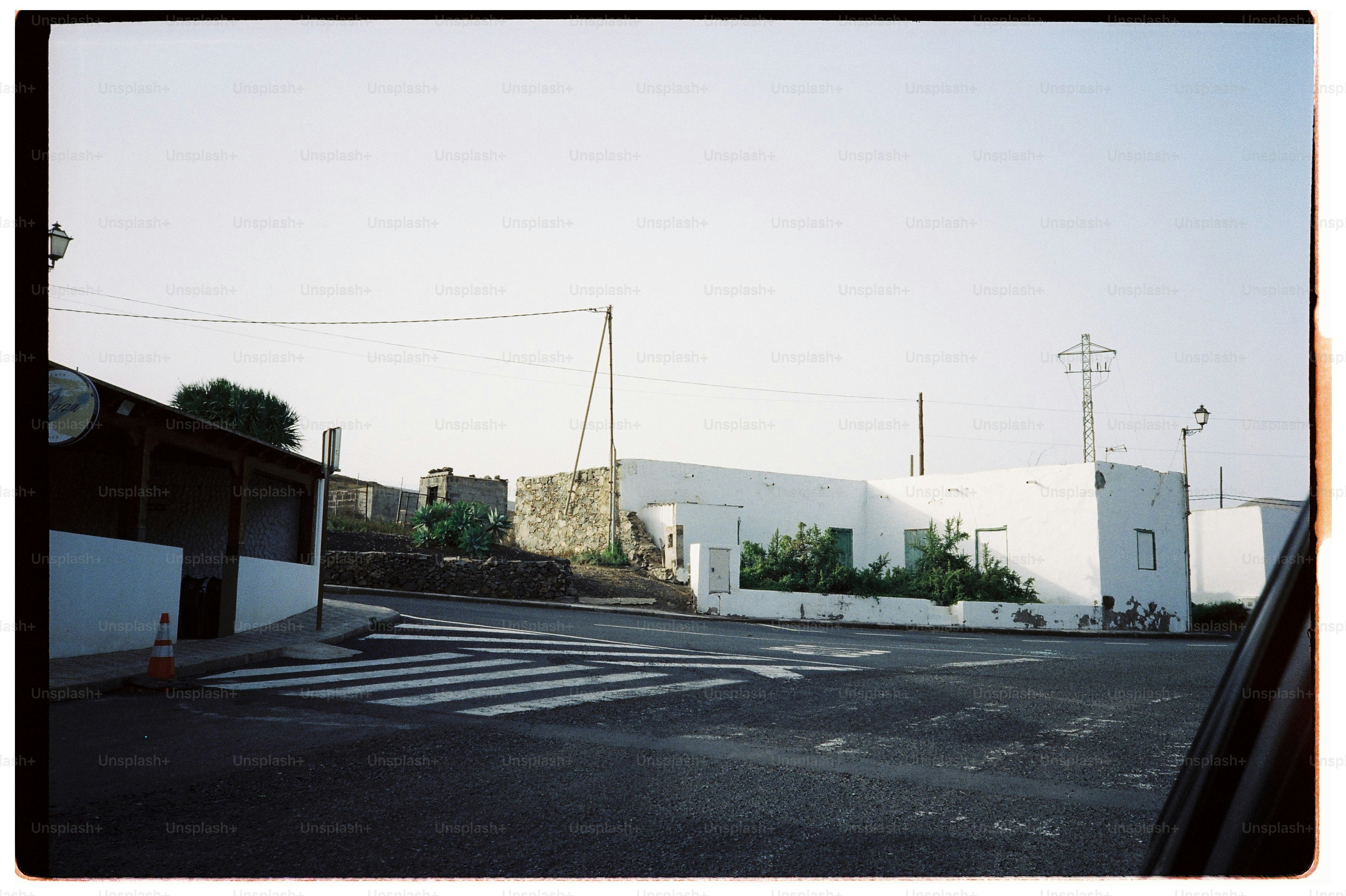 A white building with a crosswalk on an empty asphalt road.