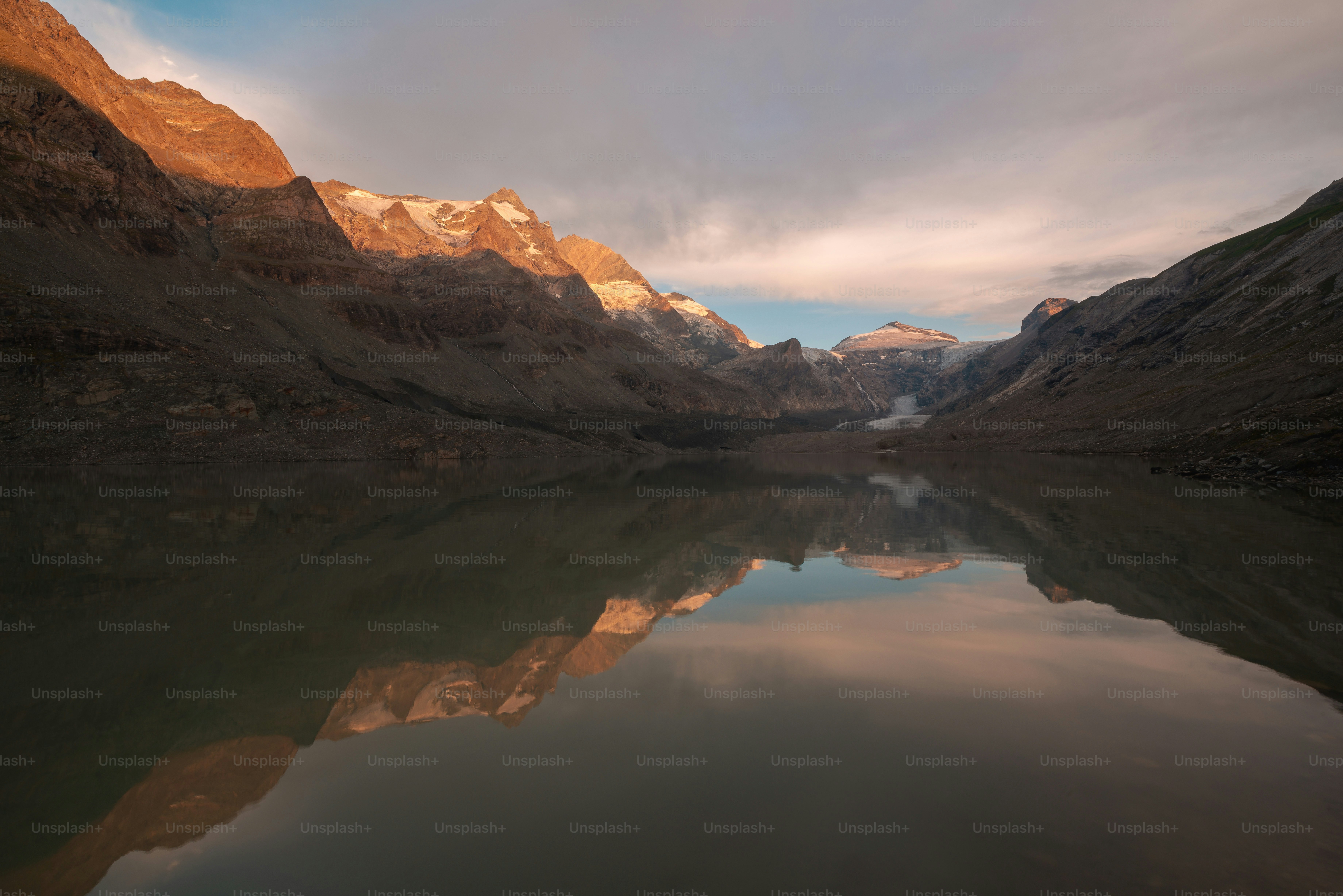 The Grossglockner mountain reflected in the calm waters of Sandersee lake in Austria