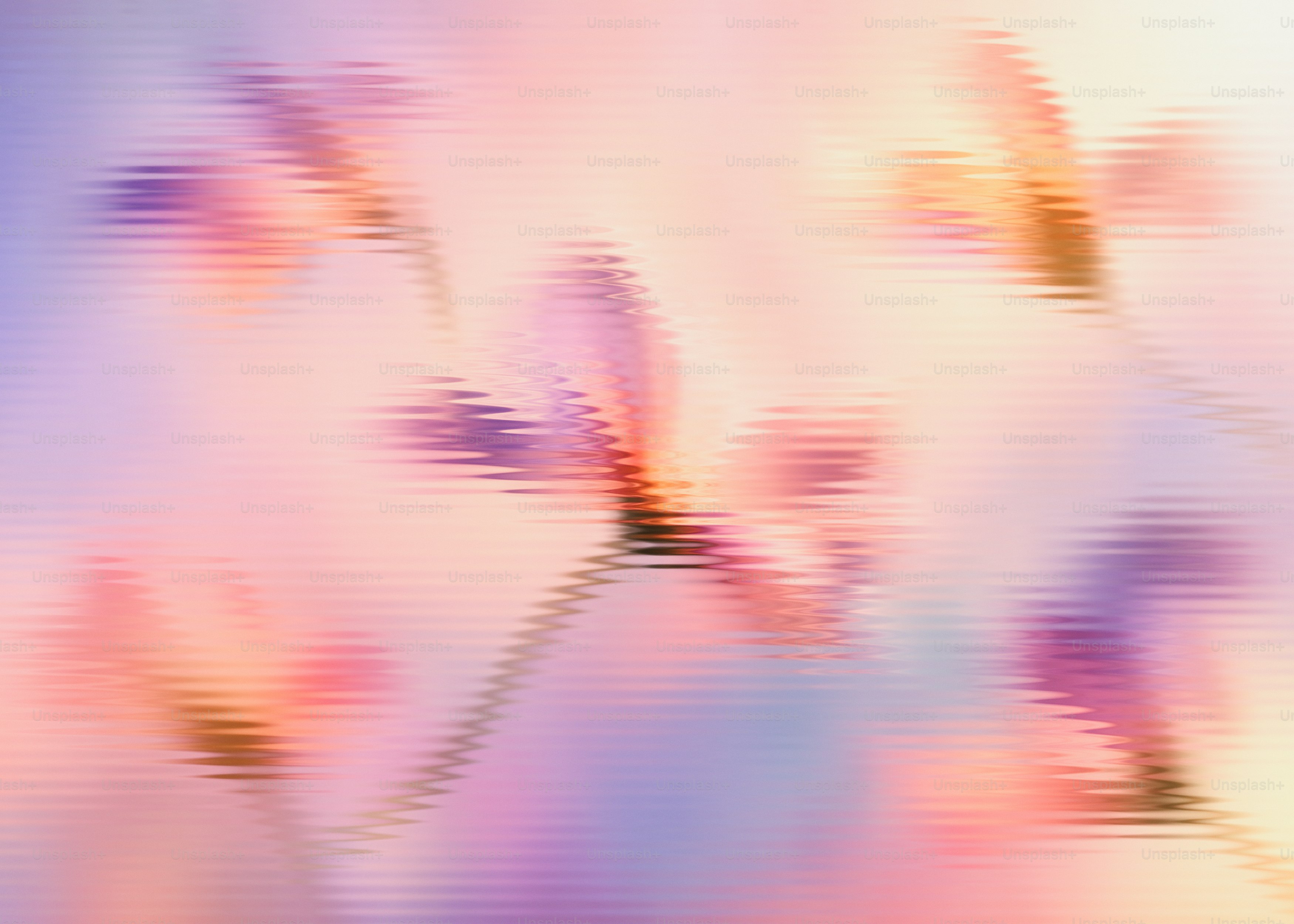 Abstract ripples of soft pink, purple, and orange light across a smooth surface