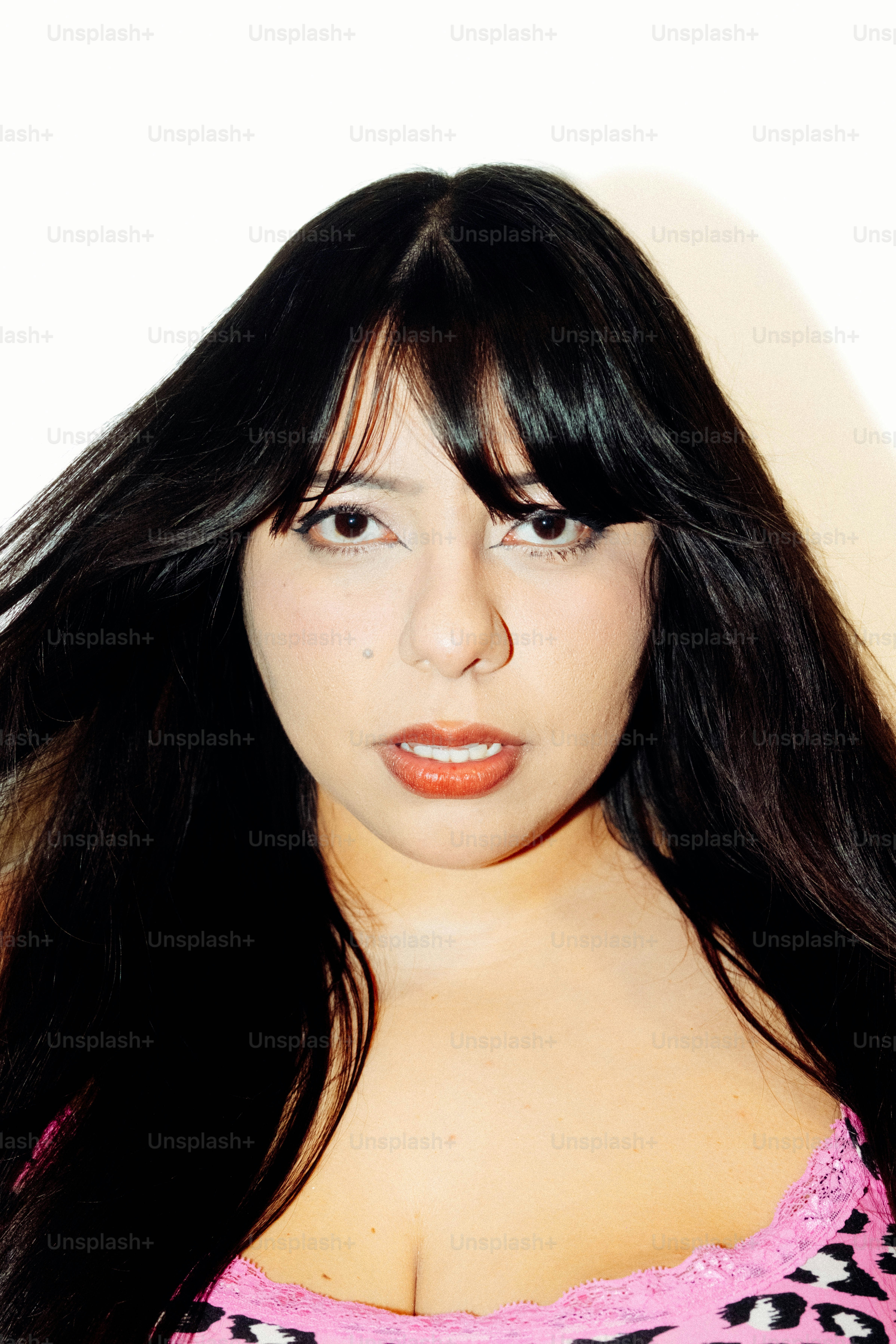 A woman with long dark hair and bangs looking directly at the camera