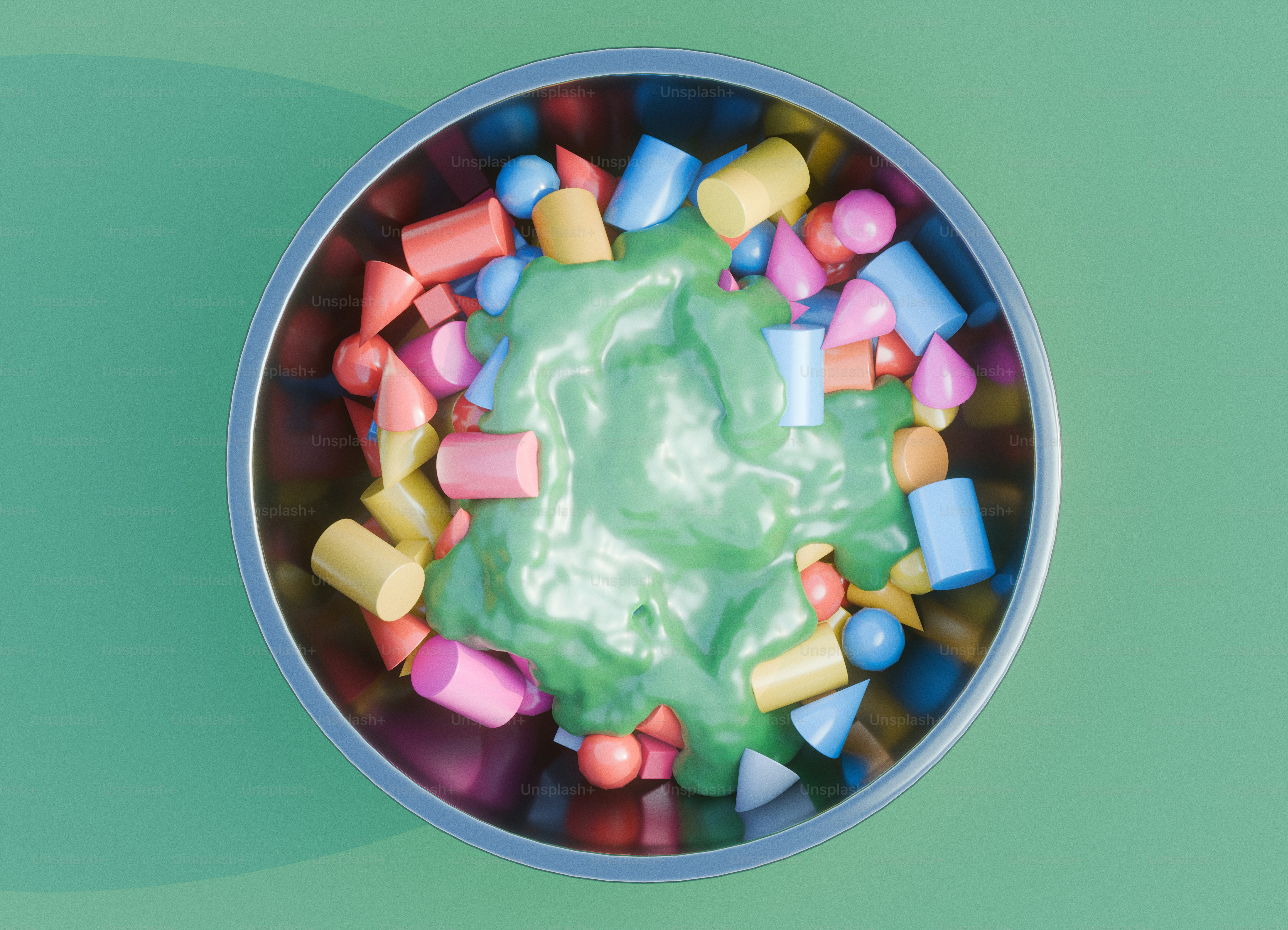 Un bol métallique rempli de formes géométriques colorées recouvertes d’un liquide vert.