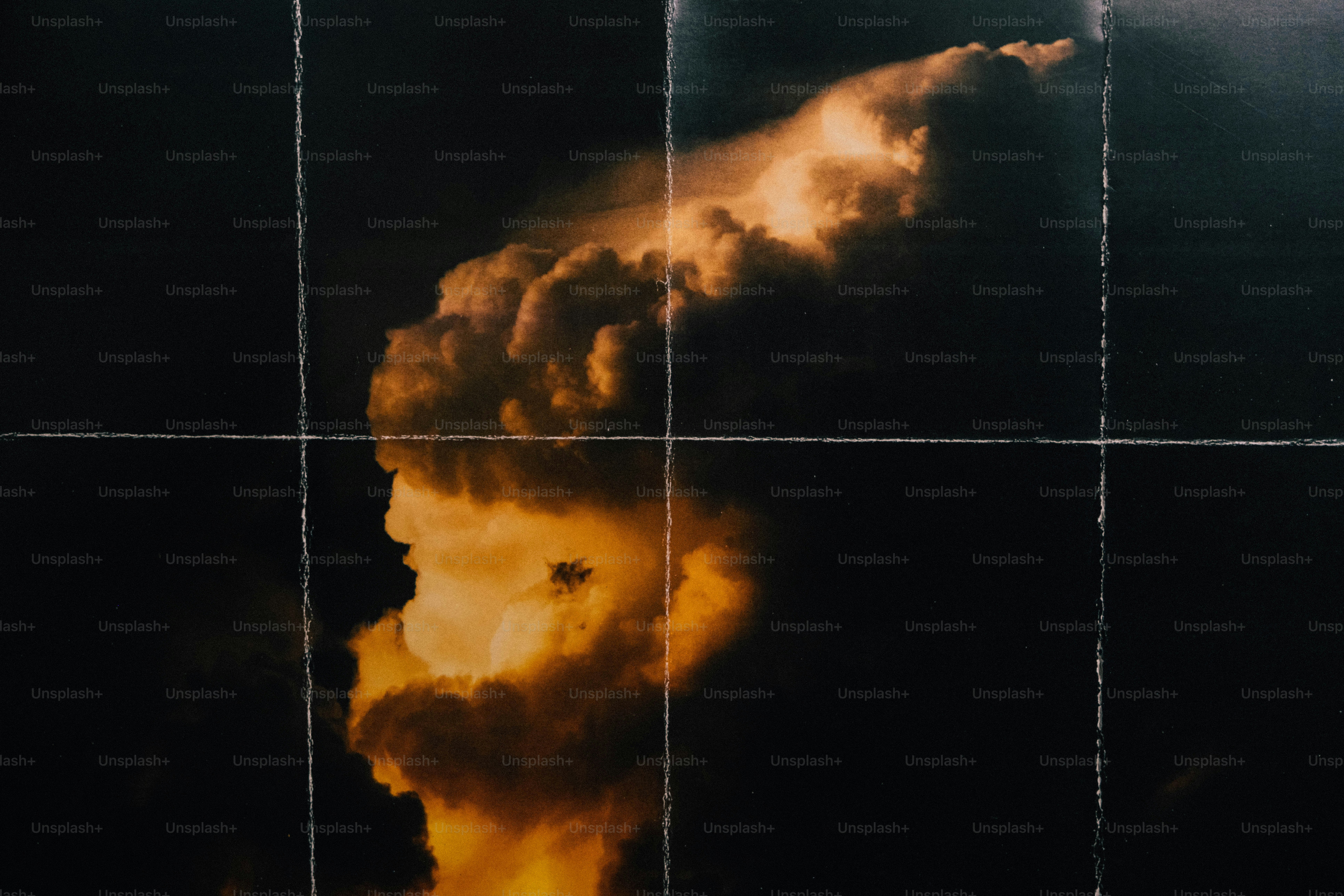 A golden cloud formation against a dark sky, divided by white grid lines.