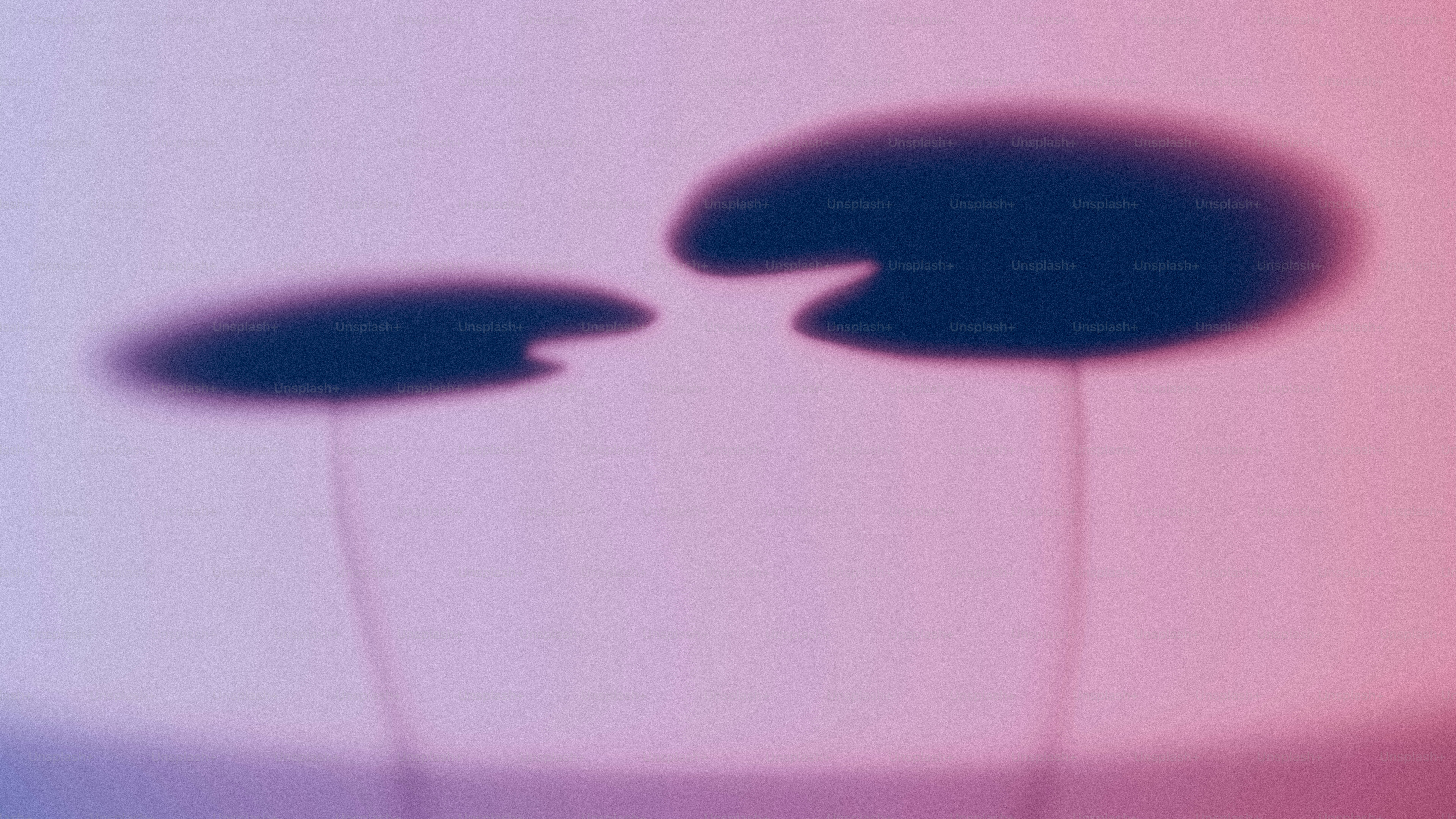 Two dark circular shadows on a soft purple and pink gradient background