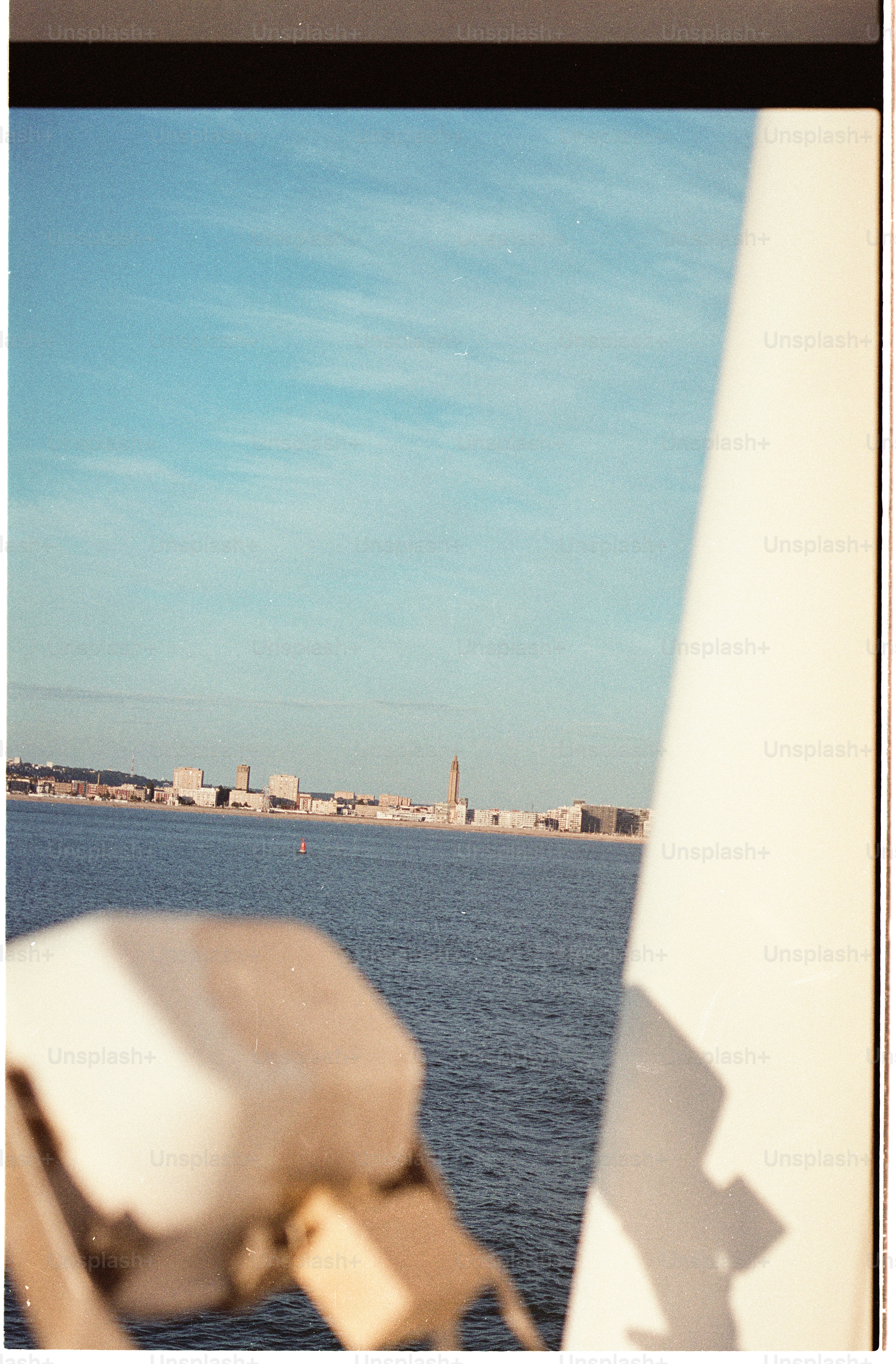 A distant coastal city skyline viewed across a wide expanse of blue water