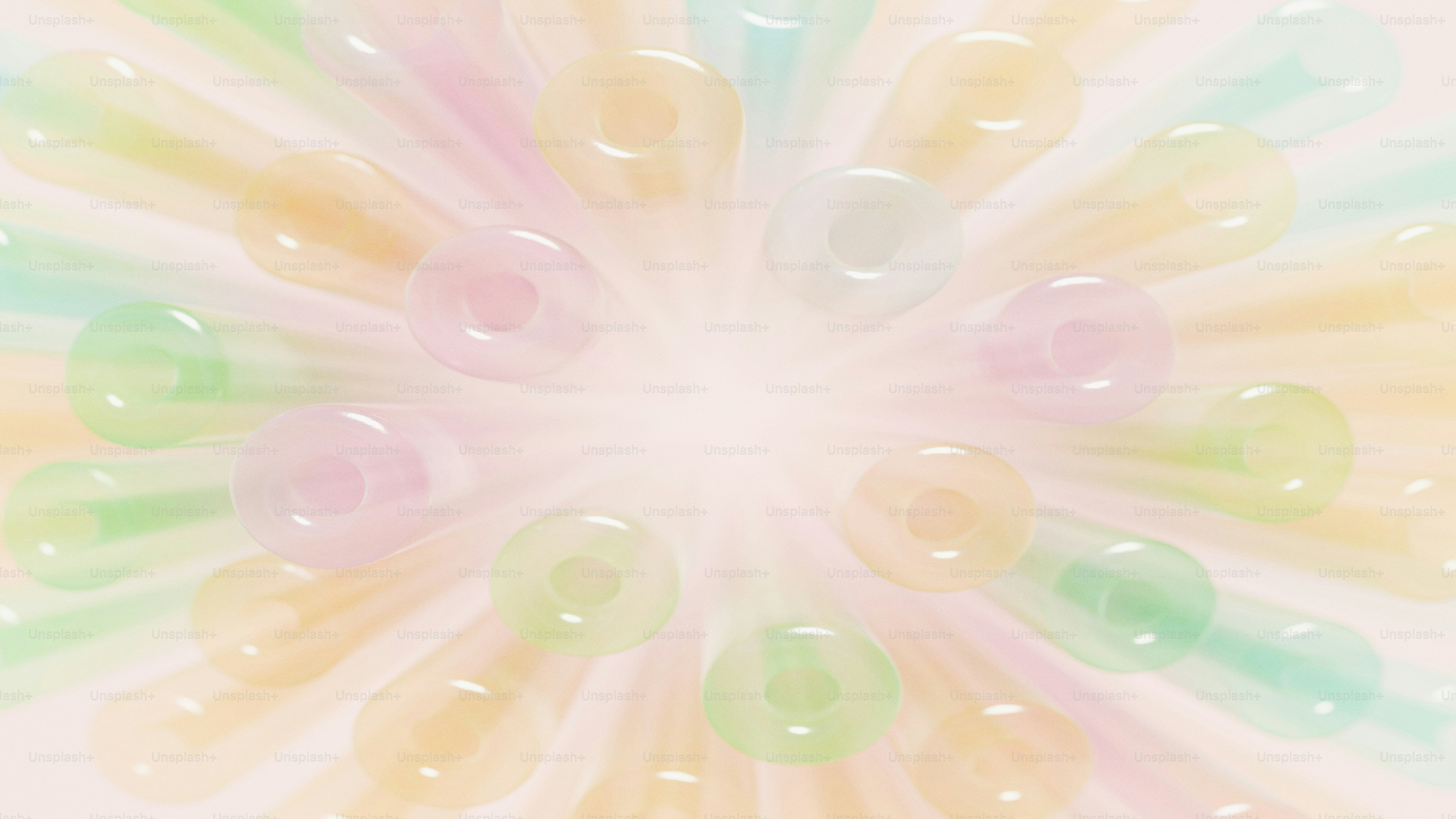 A radial arrangement of translucent pastel drinking straws in soft focus