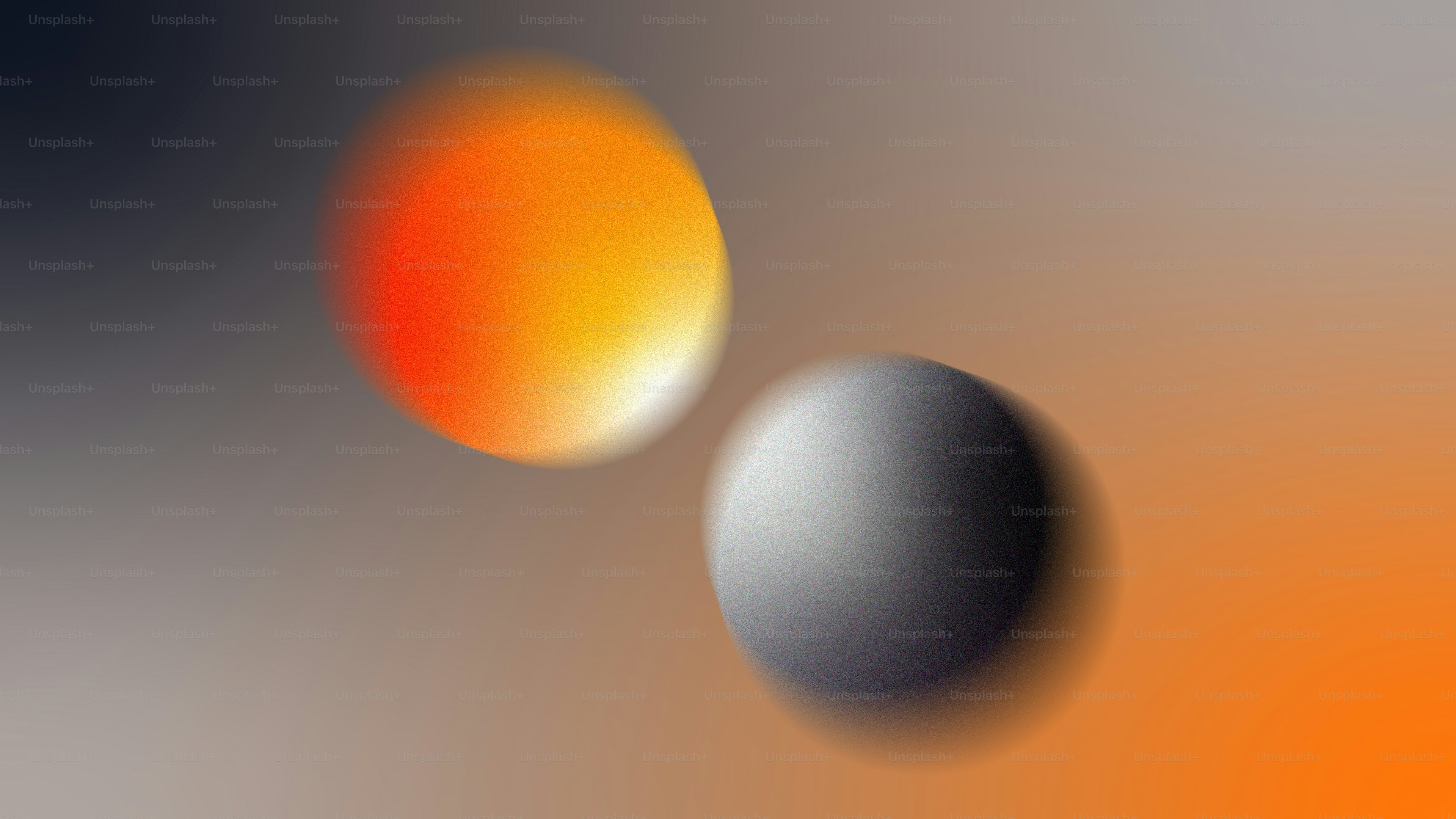Una esfera naranja borrosa y una esfera gris sobre un fondo de degradado suave