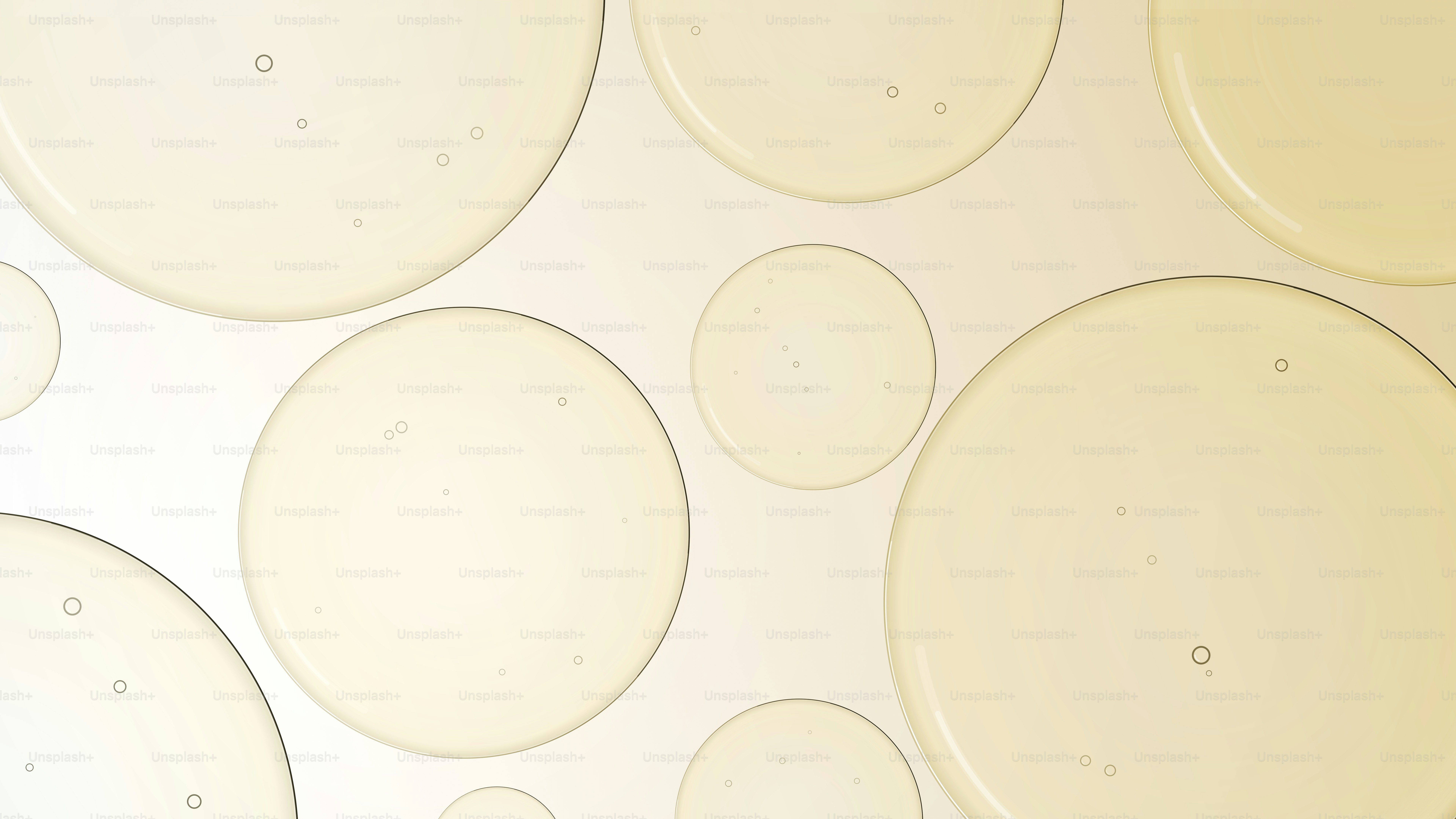 Yellow oil droplets floating on a pale, light-colored liquid surface.