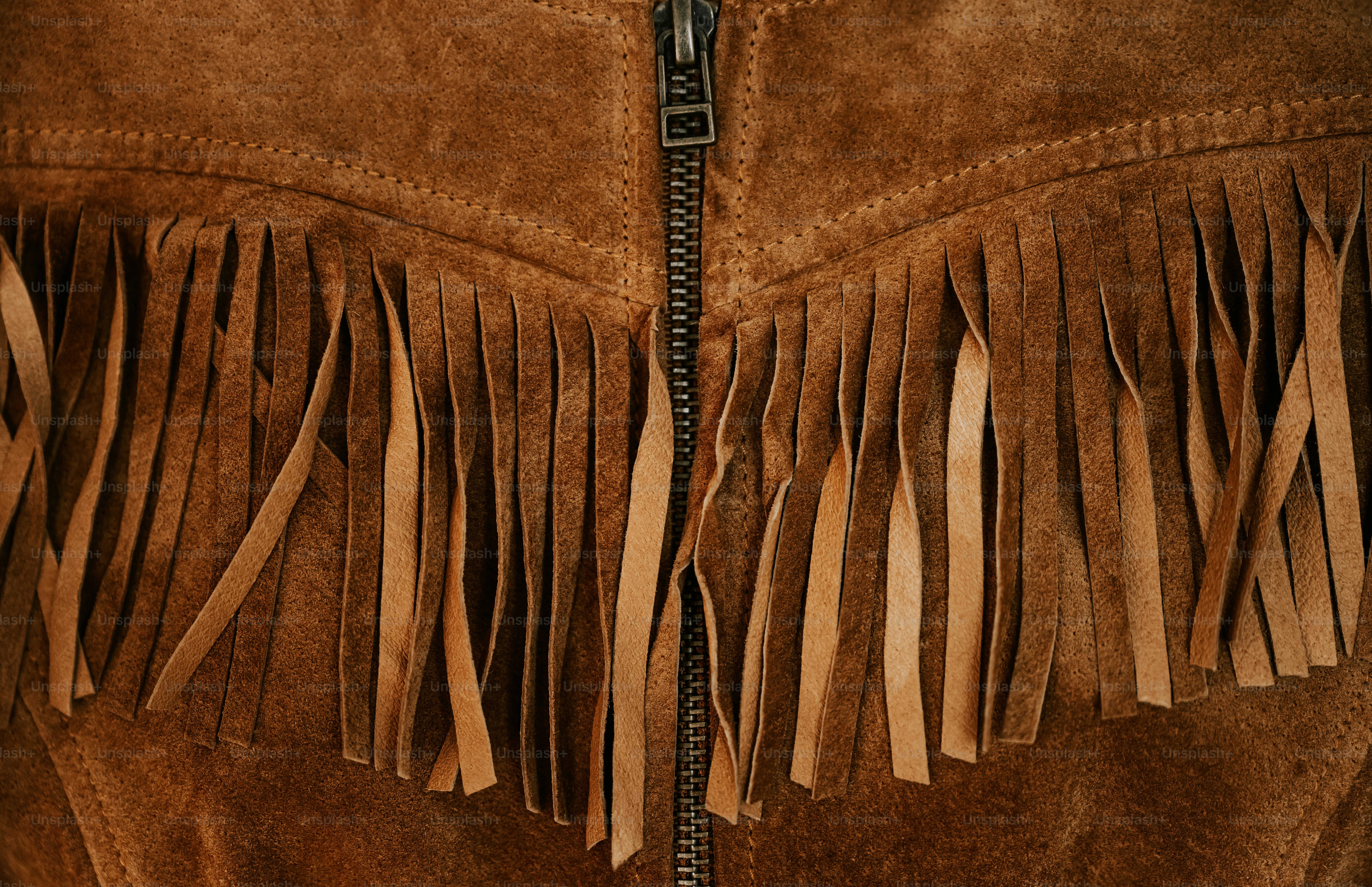 Brown suede fabric with long fringe and a central metal zipper.