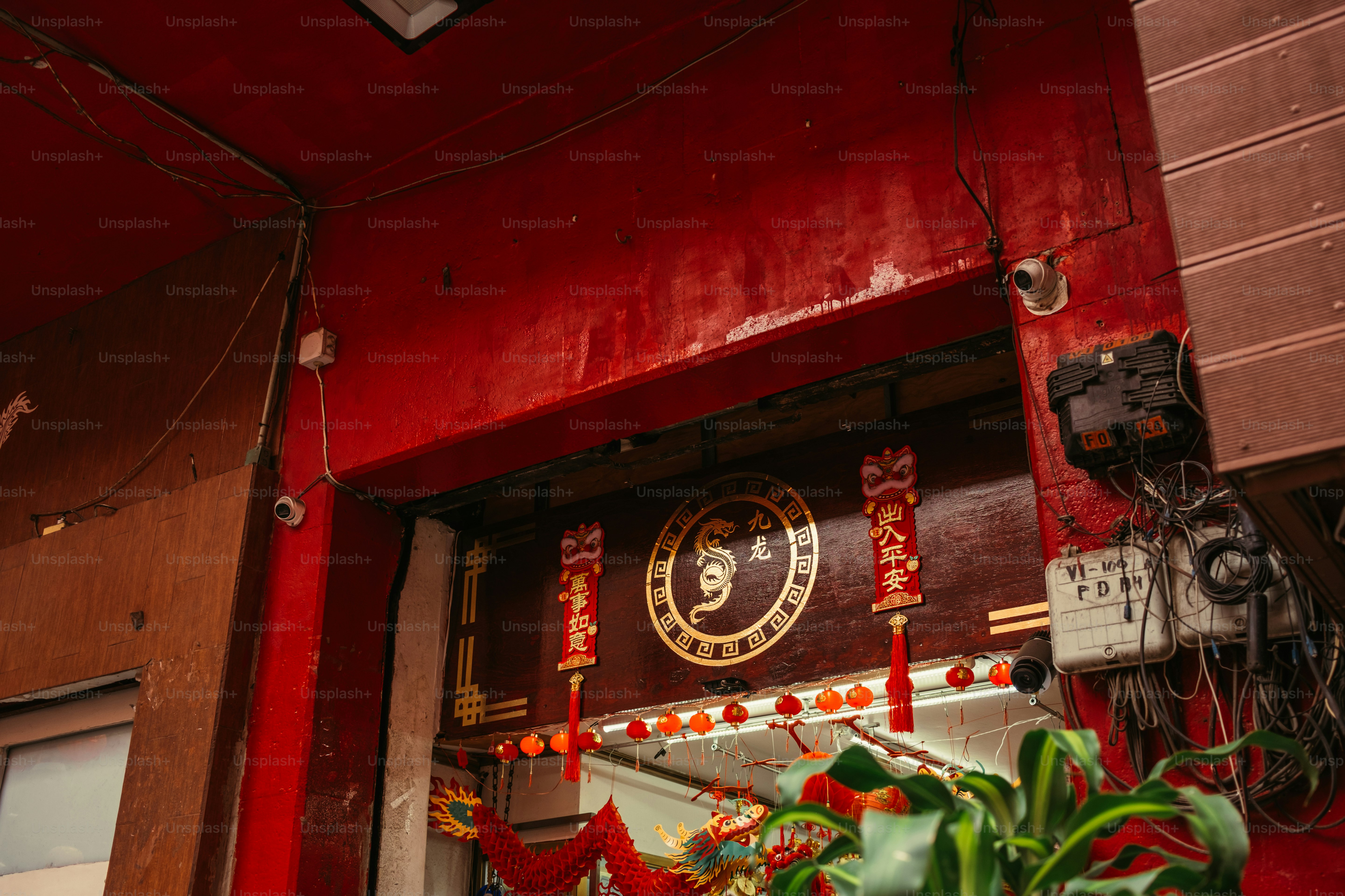 Une façade rouge avec un emblème circulaire du dragon et des lanternes rouges suspendues