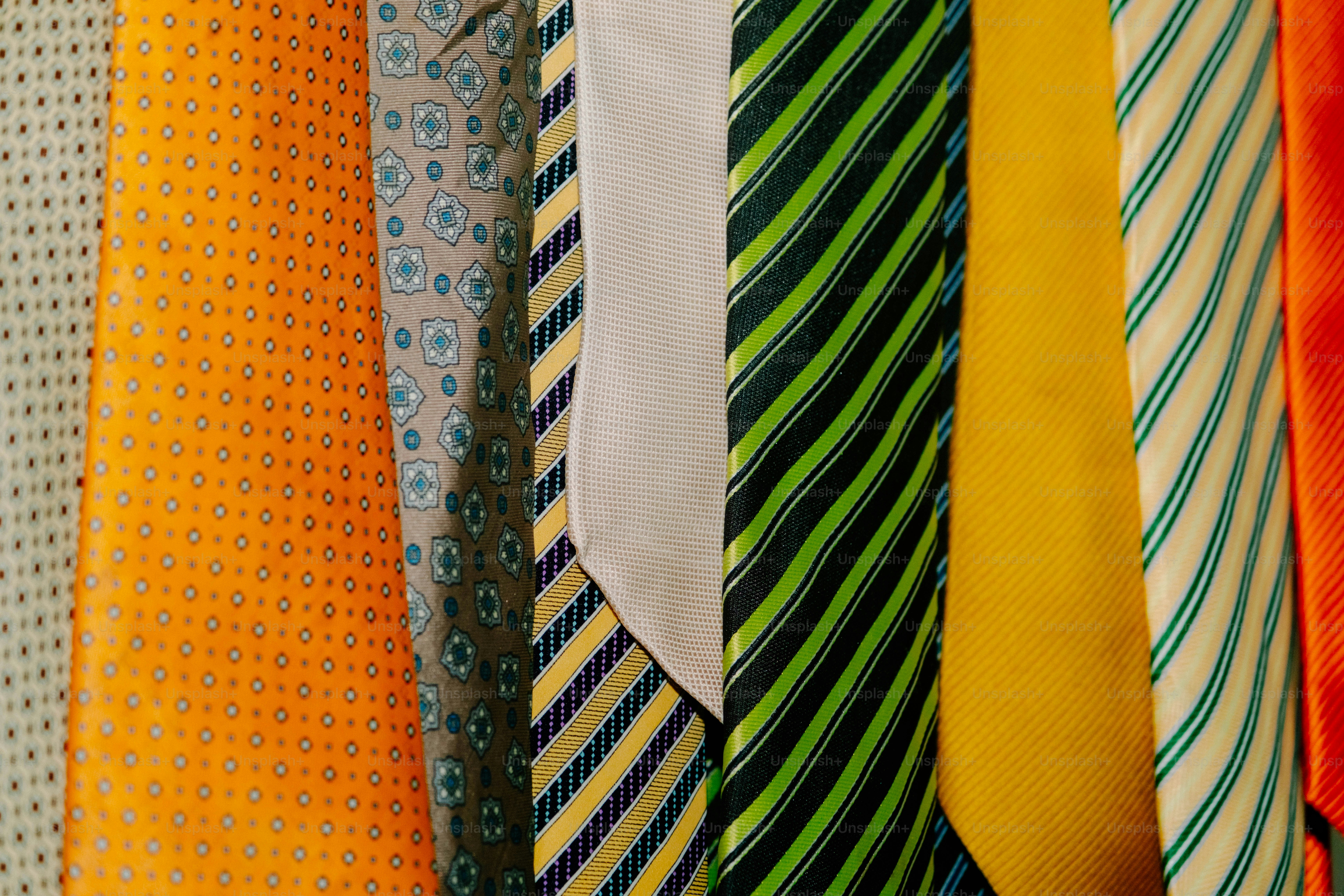 A collection of colorful neckties with various patterns hanging side by side