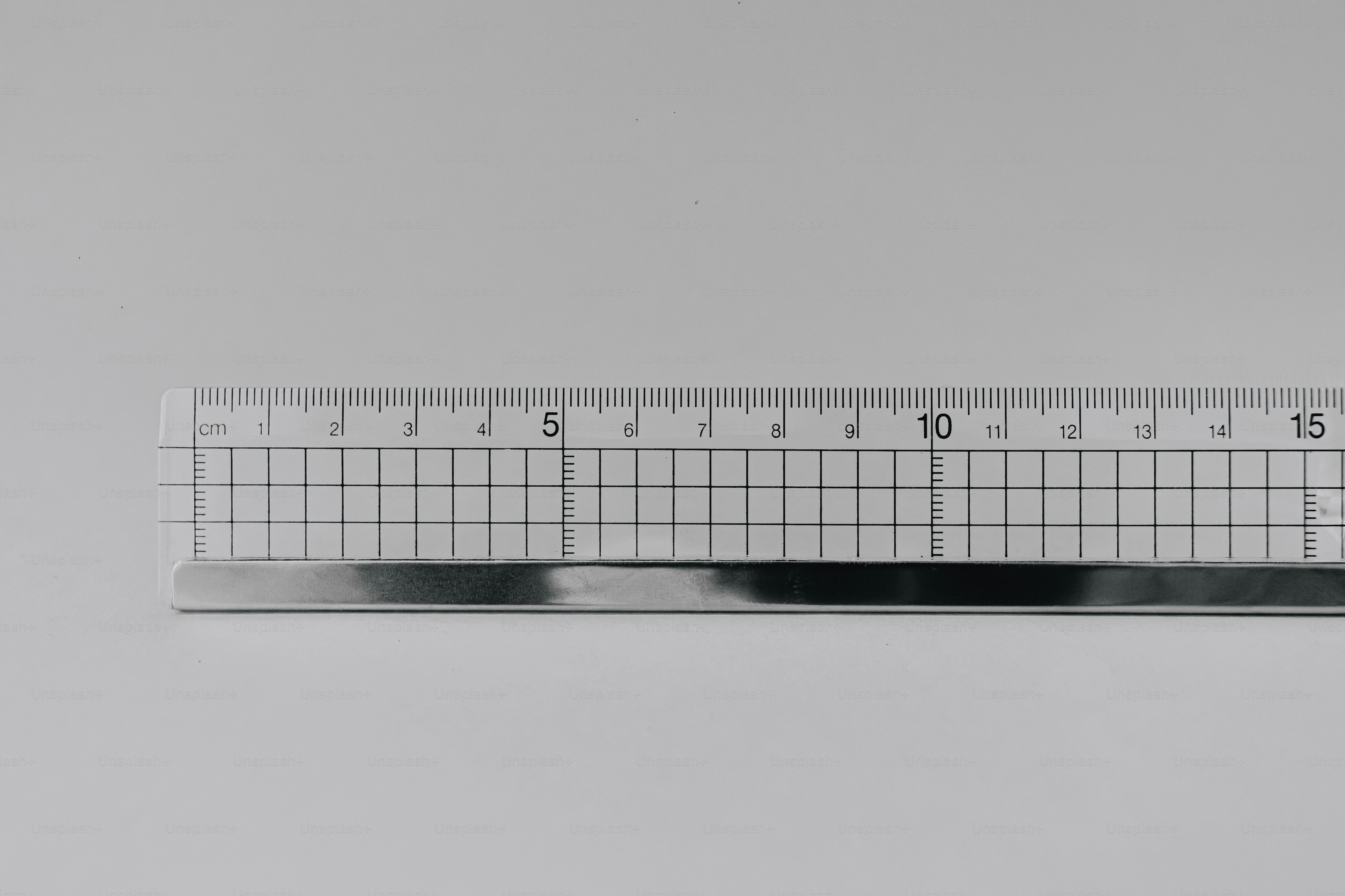 A clear plastic ruler with a metal edge against a plain white background.