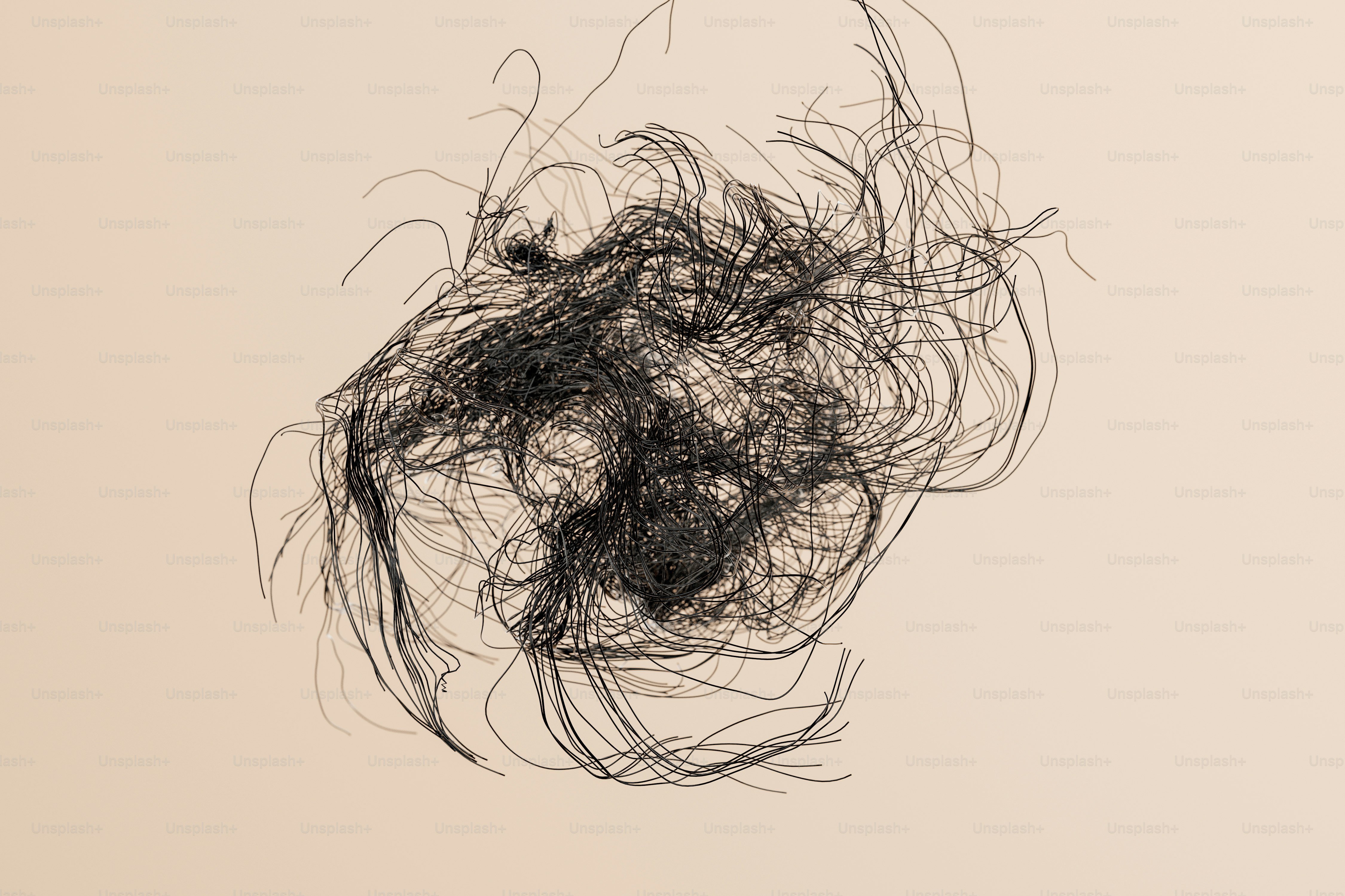 A tangled mass of thin black wire on a light beige background