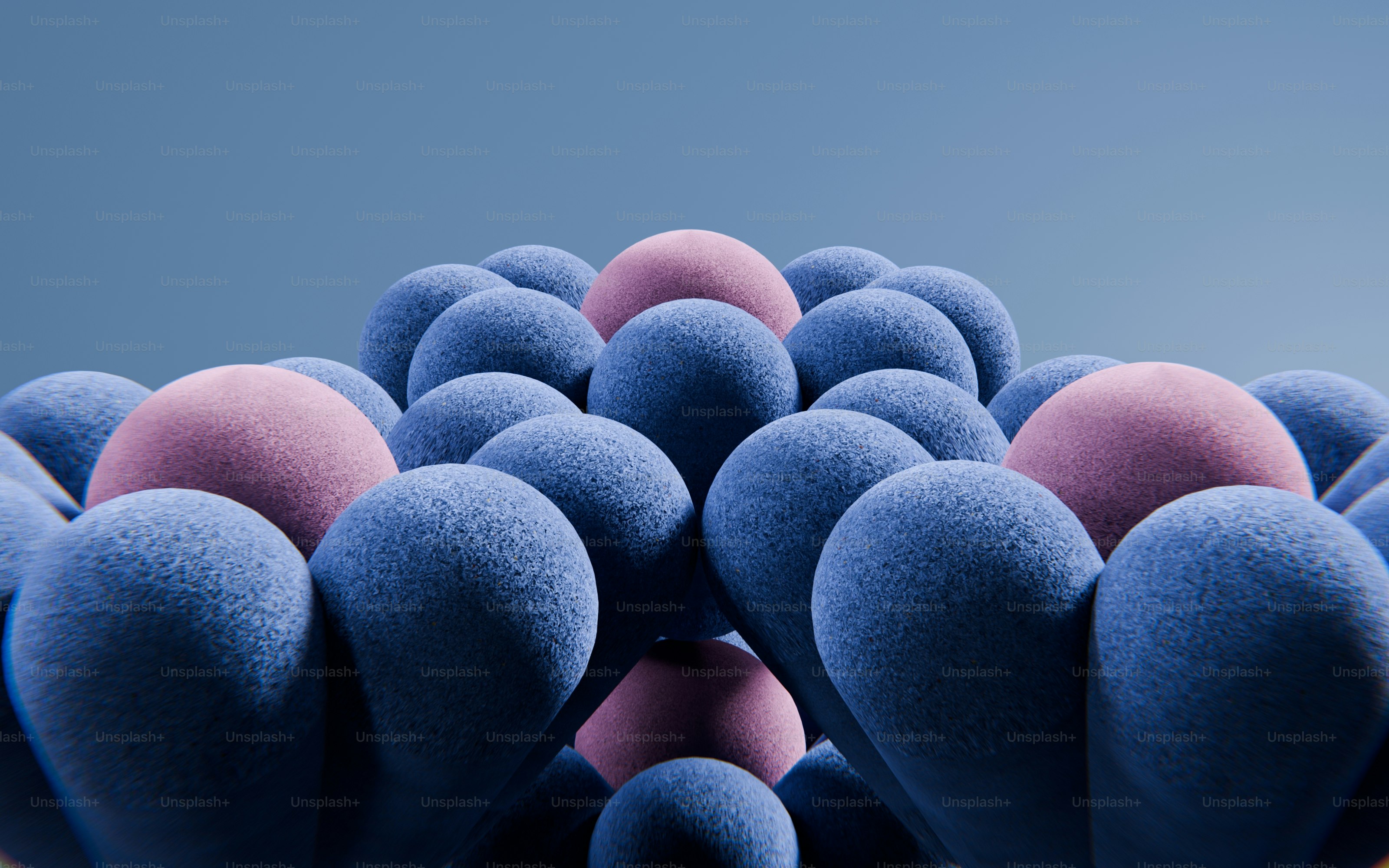 Eine Ansammlung strukturierter blauer und rosa Kugeln, die in einem geometrischen Muster angeordnet waren
