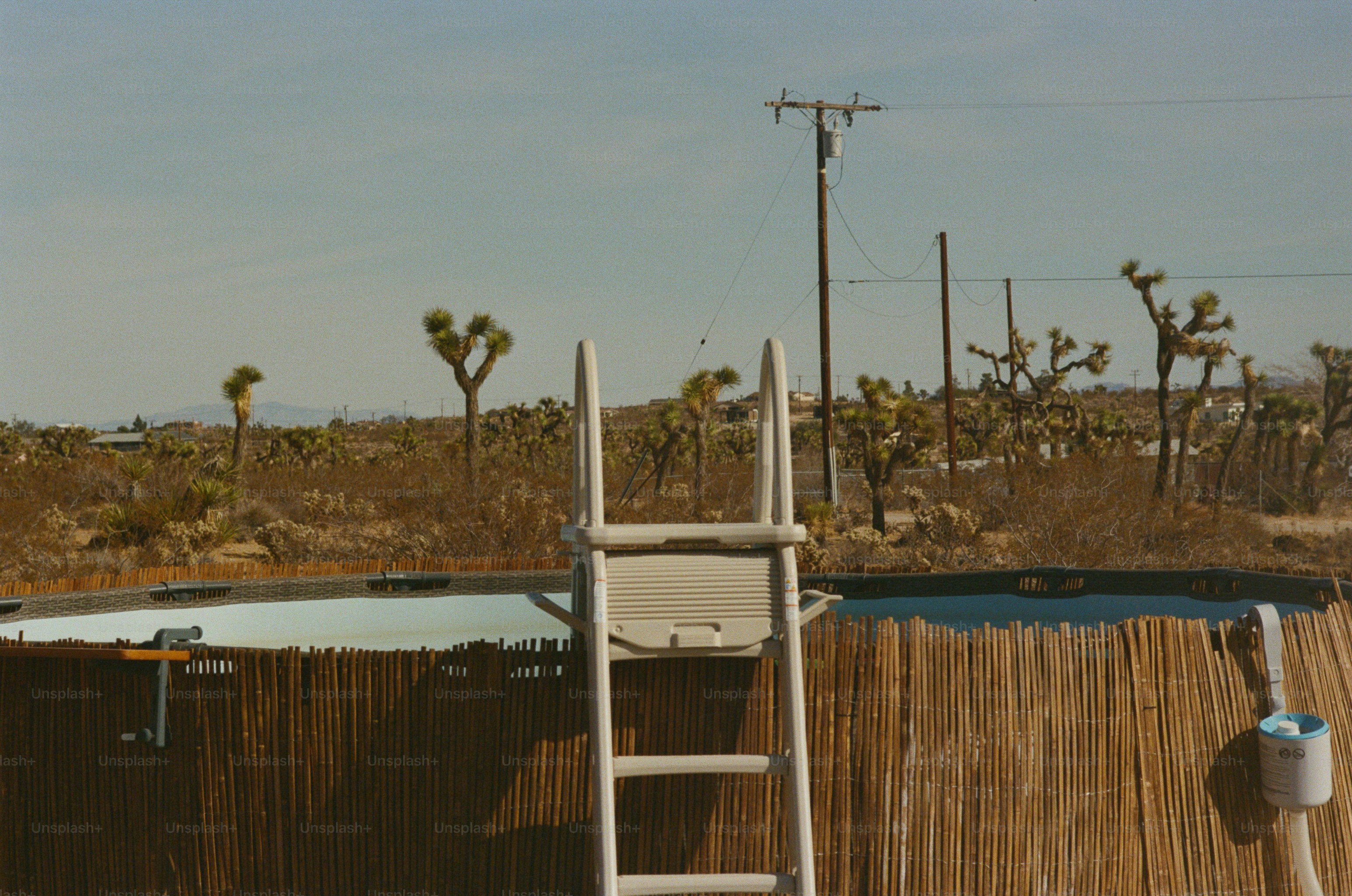 An above-ground pool with bamboo fencing in the Joshua Tree desert landscape