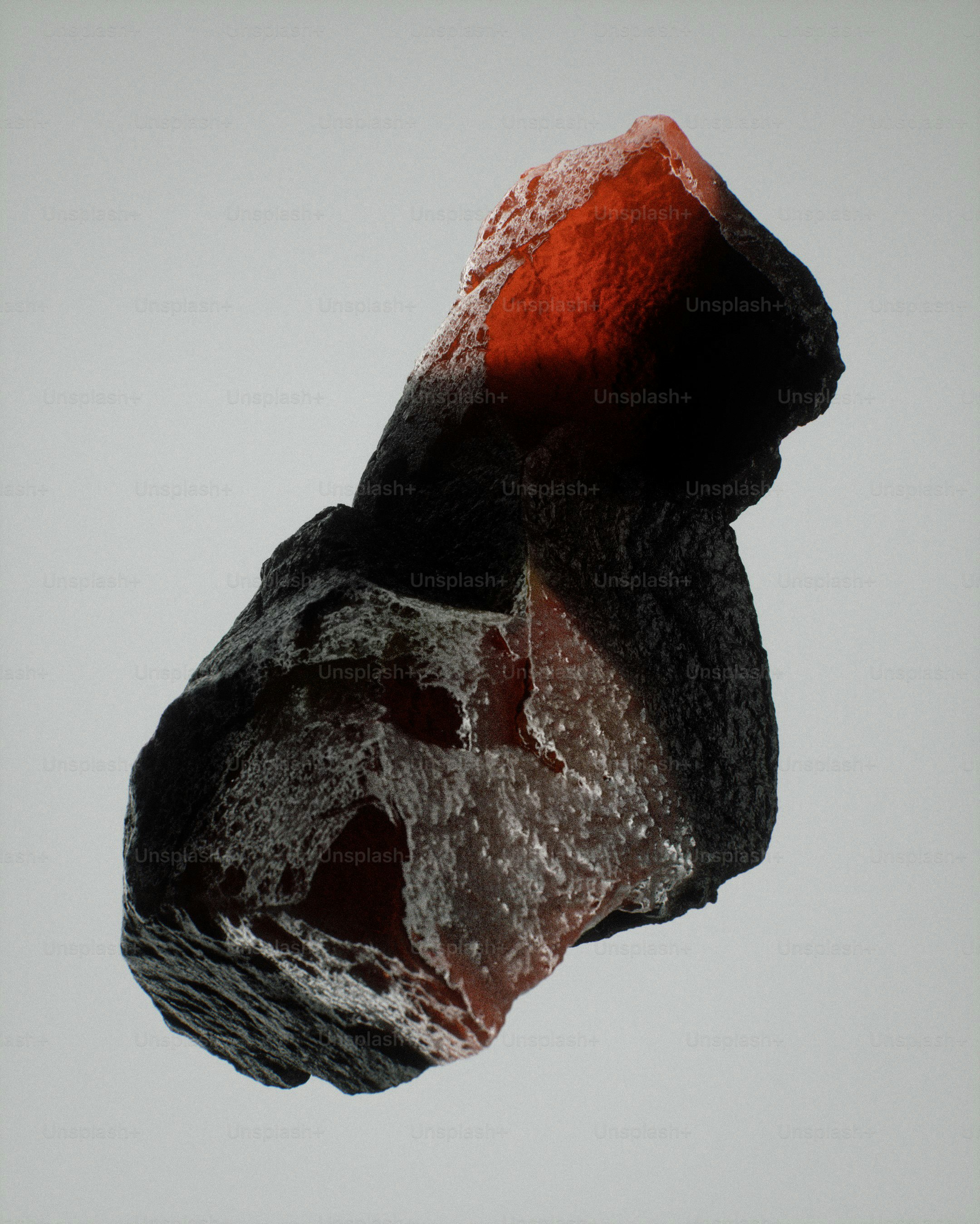 Una roca dentada con superficies oscuras y luz interior roja brillante