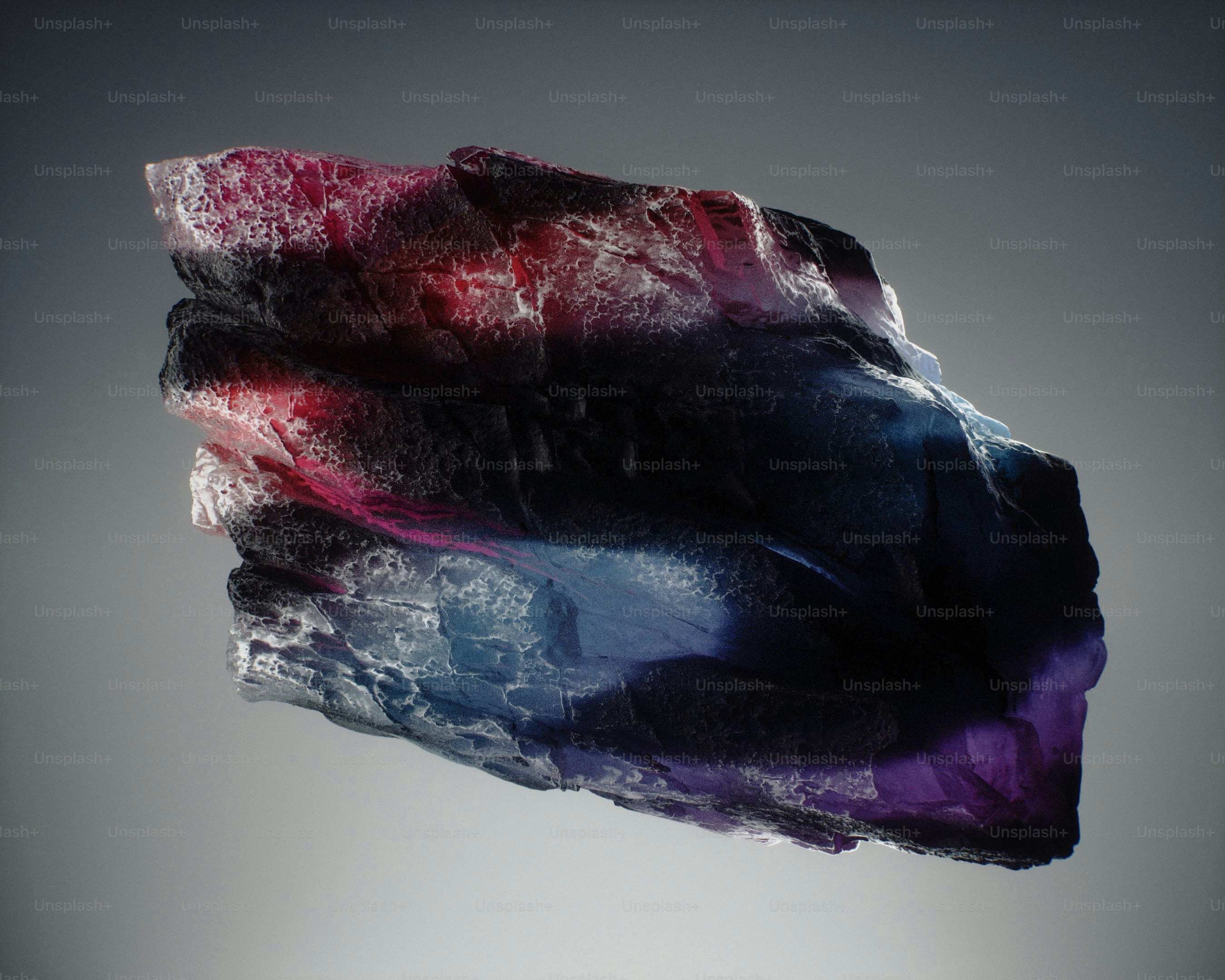 Una roca dentada con superficies texturizadas en tonos de púrpura profundo, azul y rojo