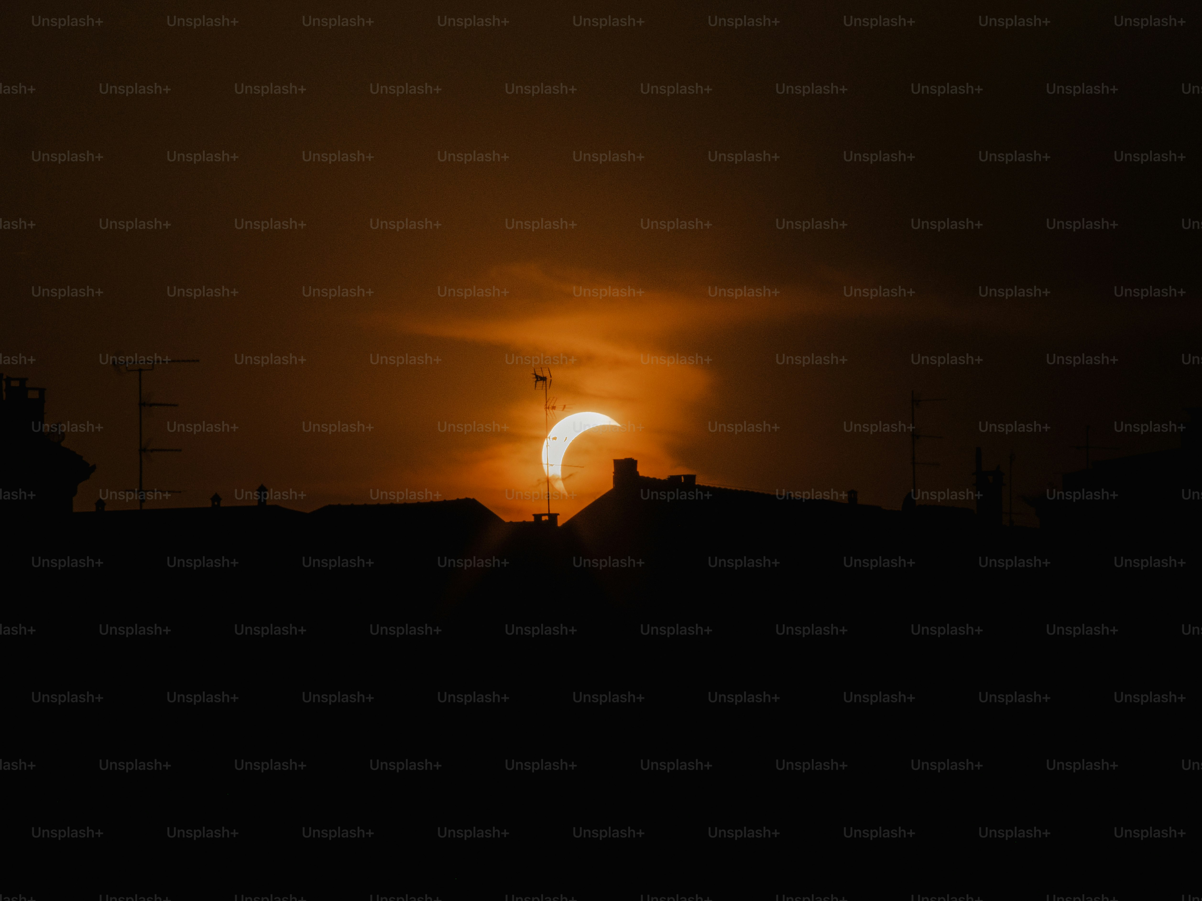 Eine teilweise Sonnenfinsternis über den silhouettierten Dächern von Mailand, Italien.