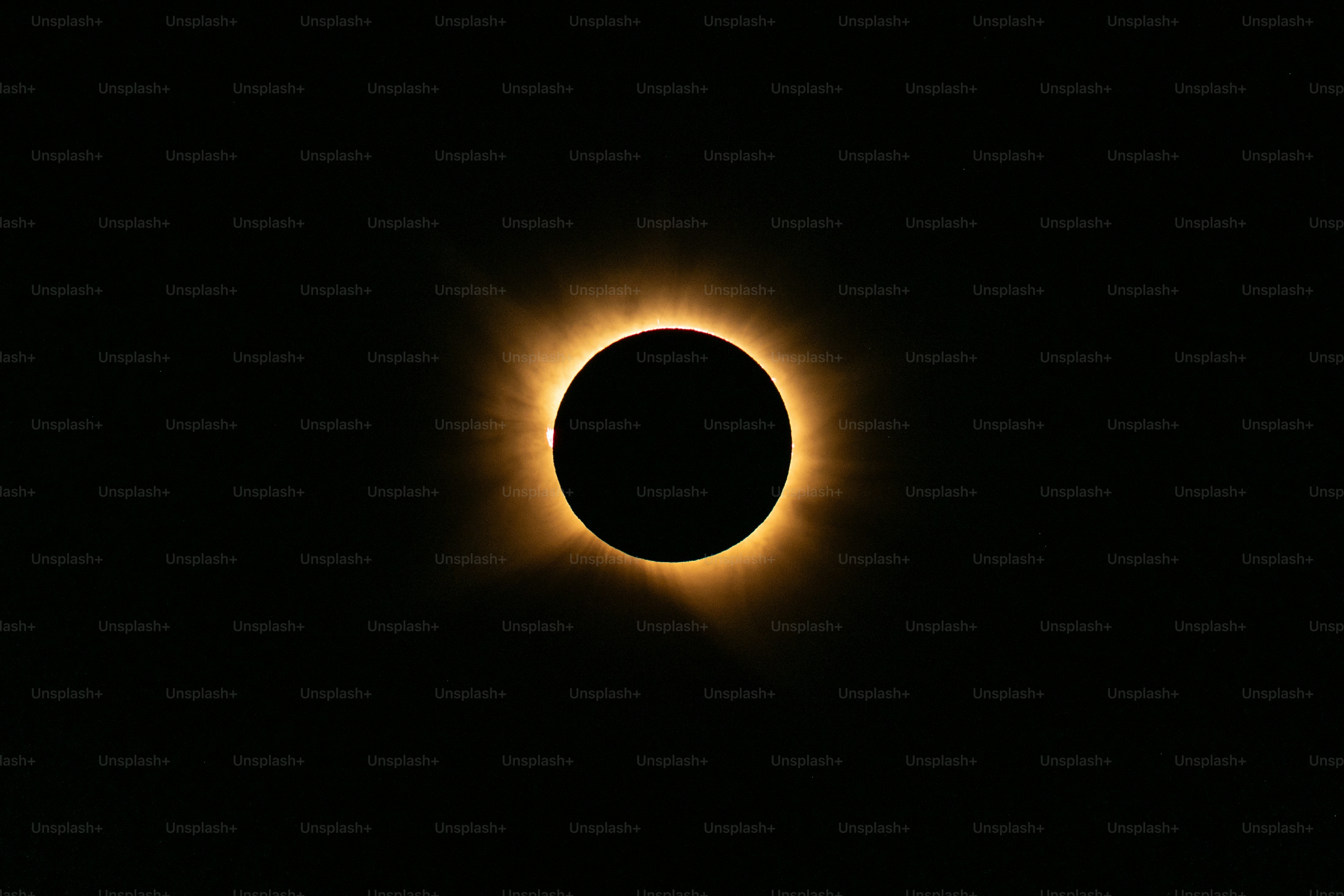 A total solar eclipse with a glowing corona against a dark black sky