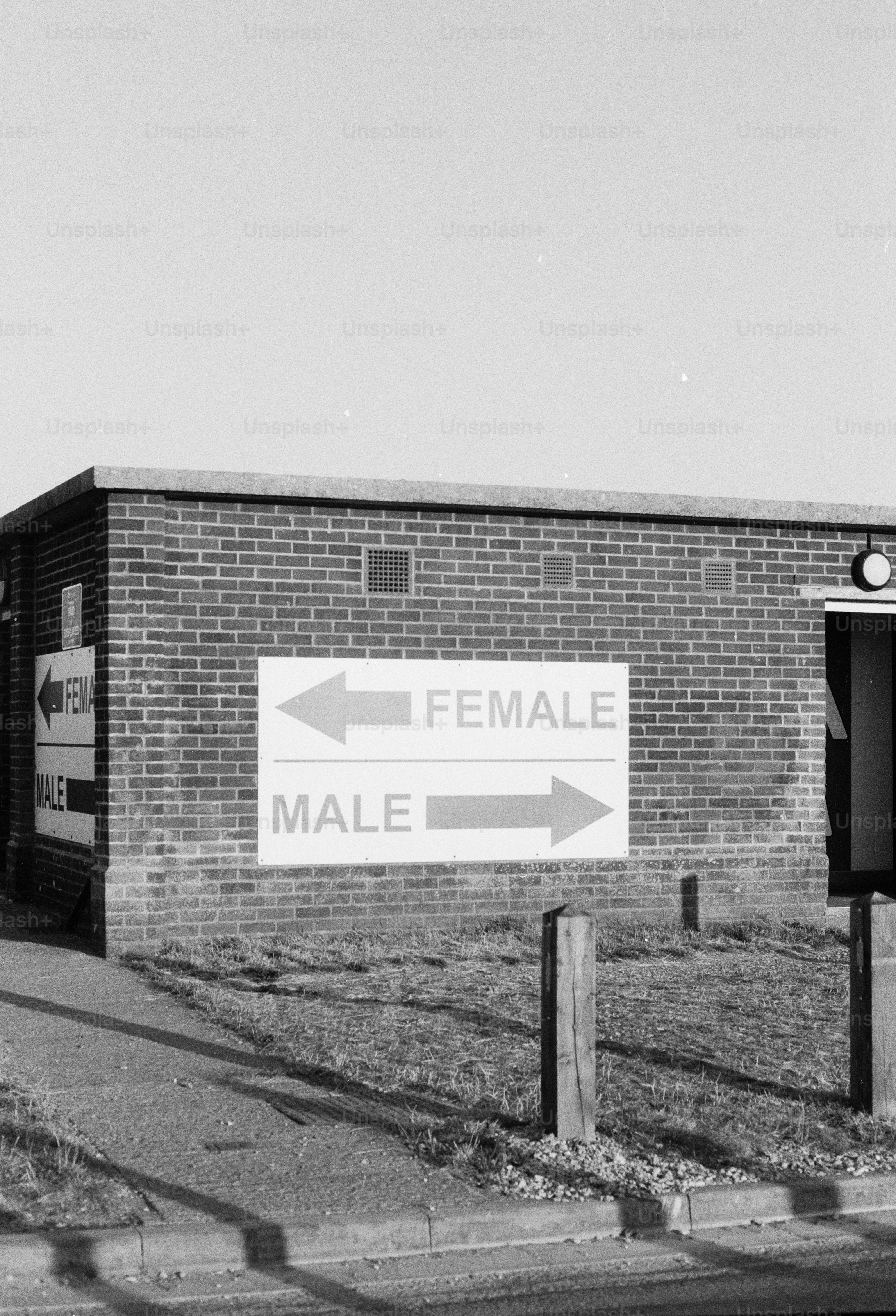 A brick building with signs pointing to female and male restrooms