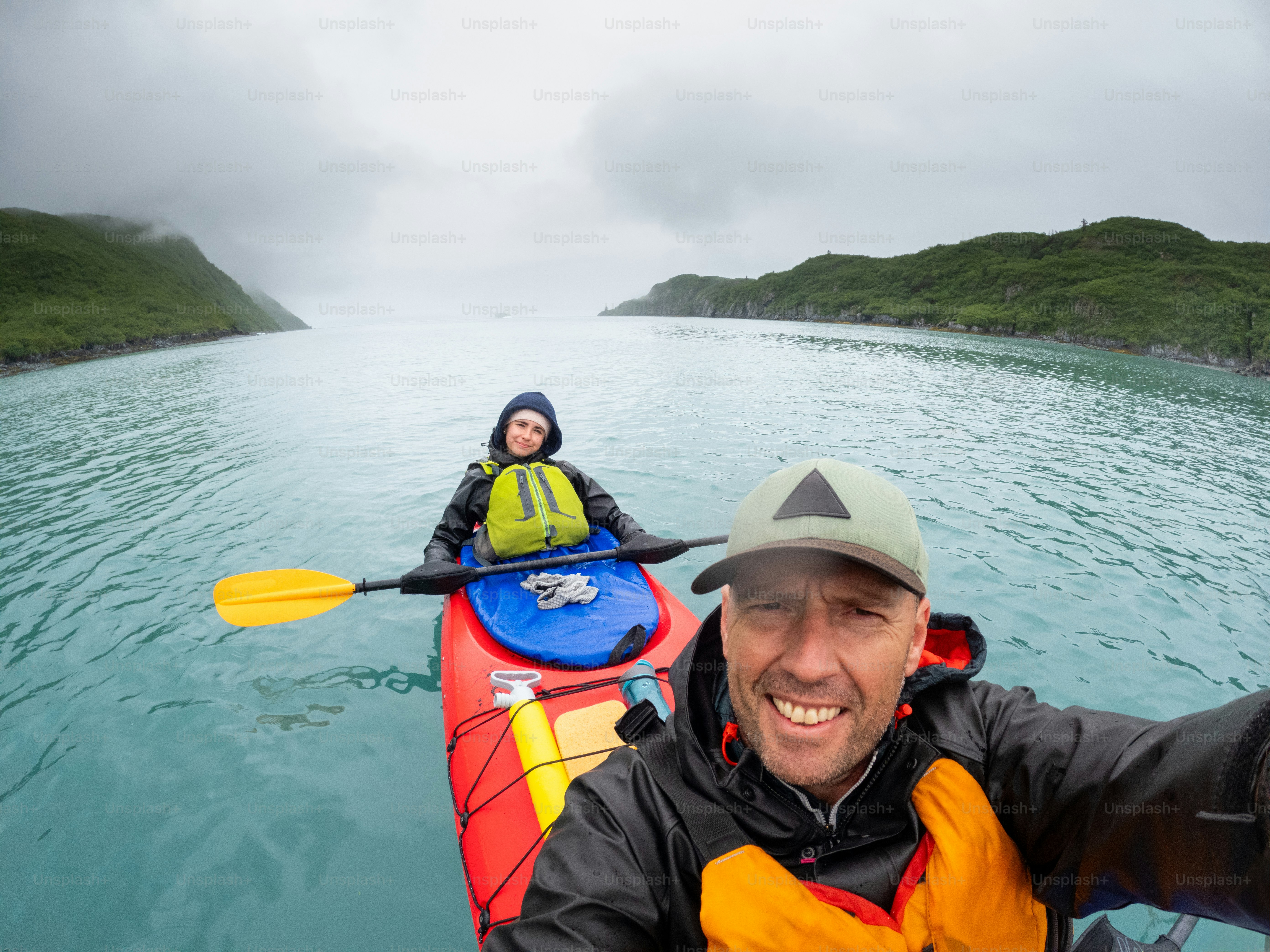 Padre e hija adolescente haciendo kayak hasta el glaciar Aialik en Alaska