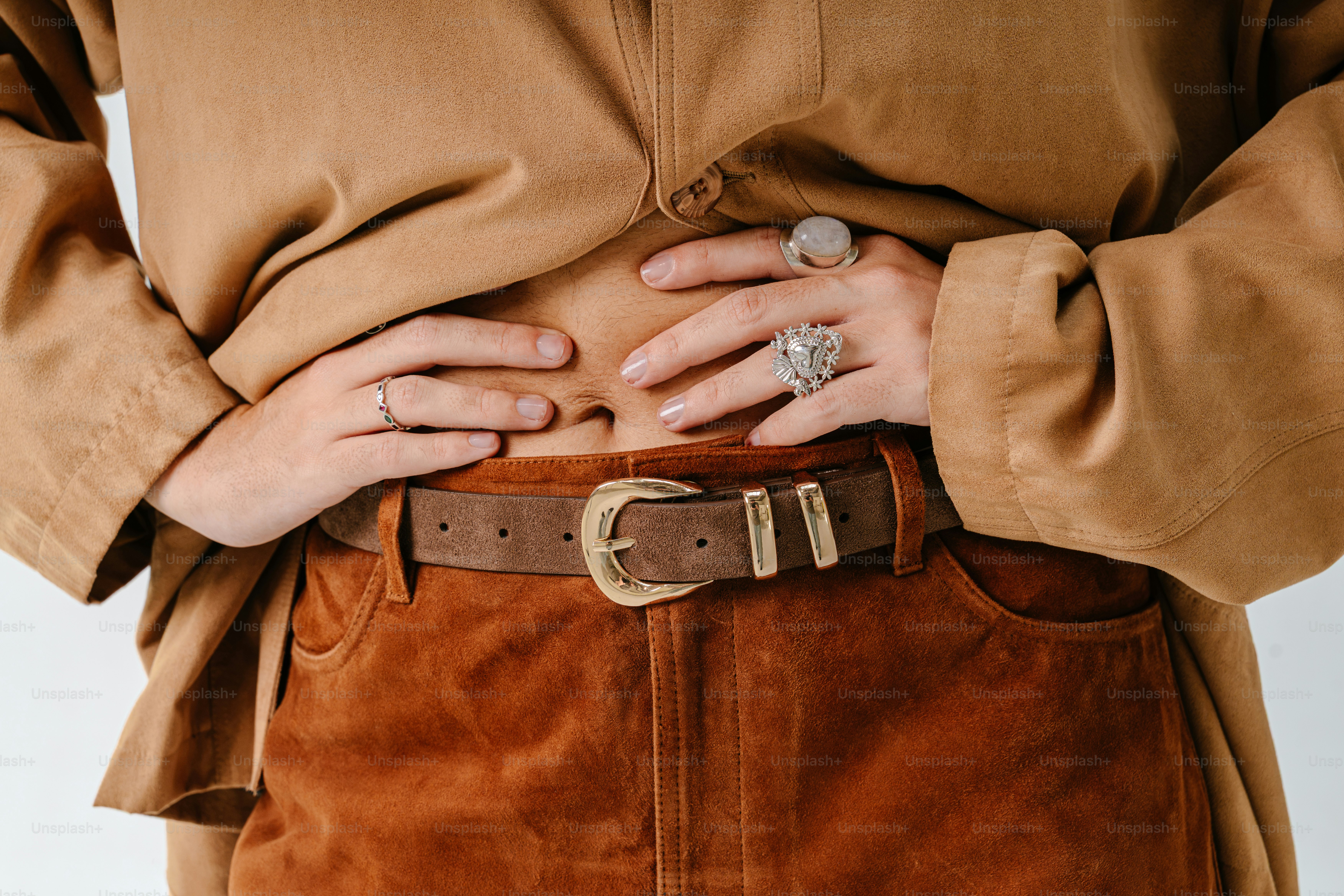 Eine Person in einem beigefarbenen Wildlederhemd und braunen Wildlederhosen mit Gürtel
