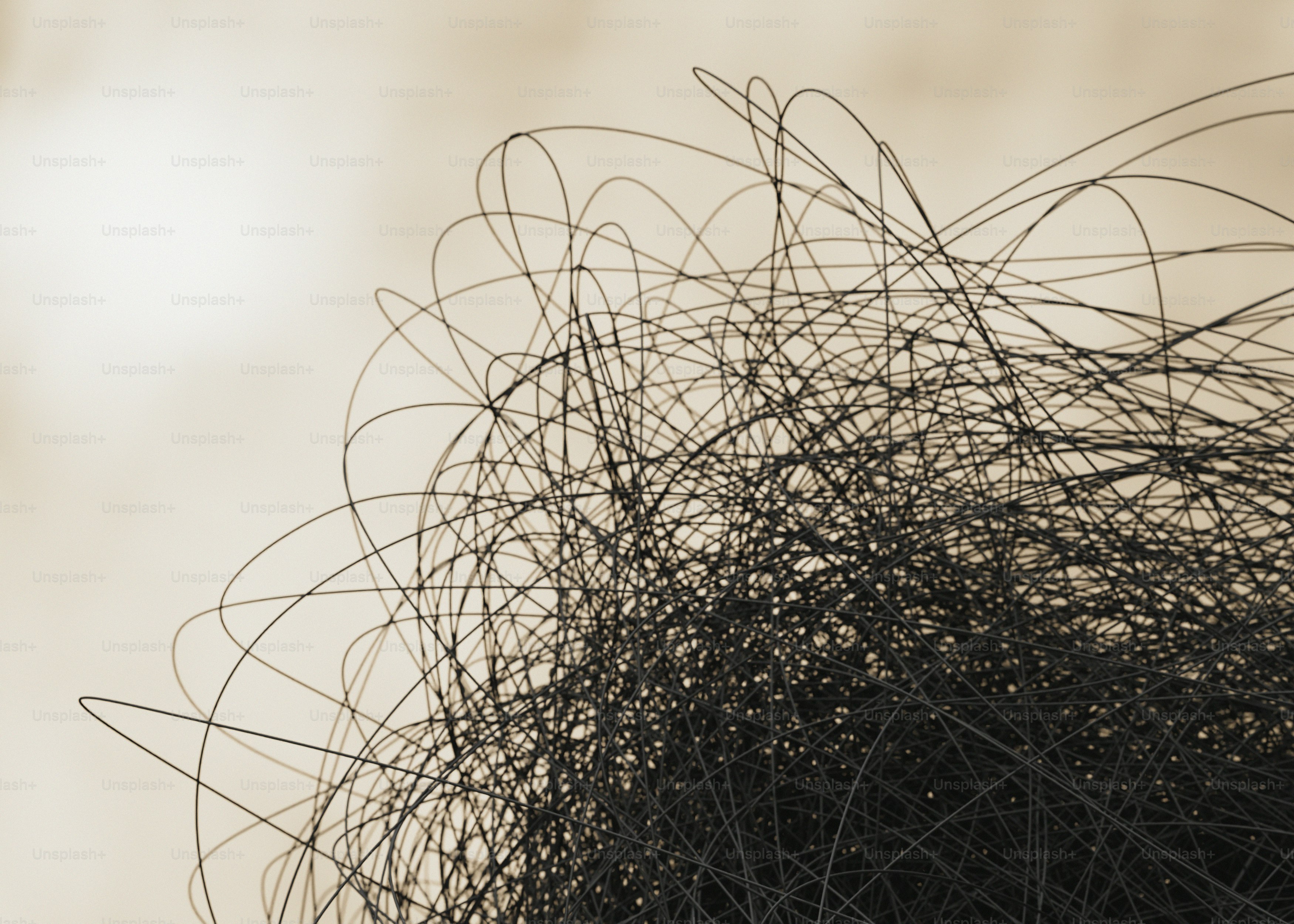 A tangled mass of thin black wire against a light beige background