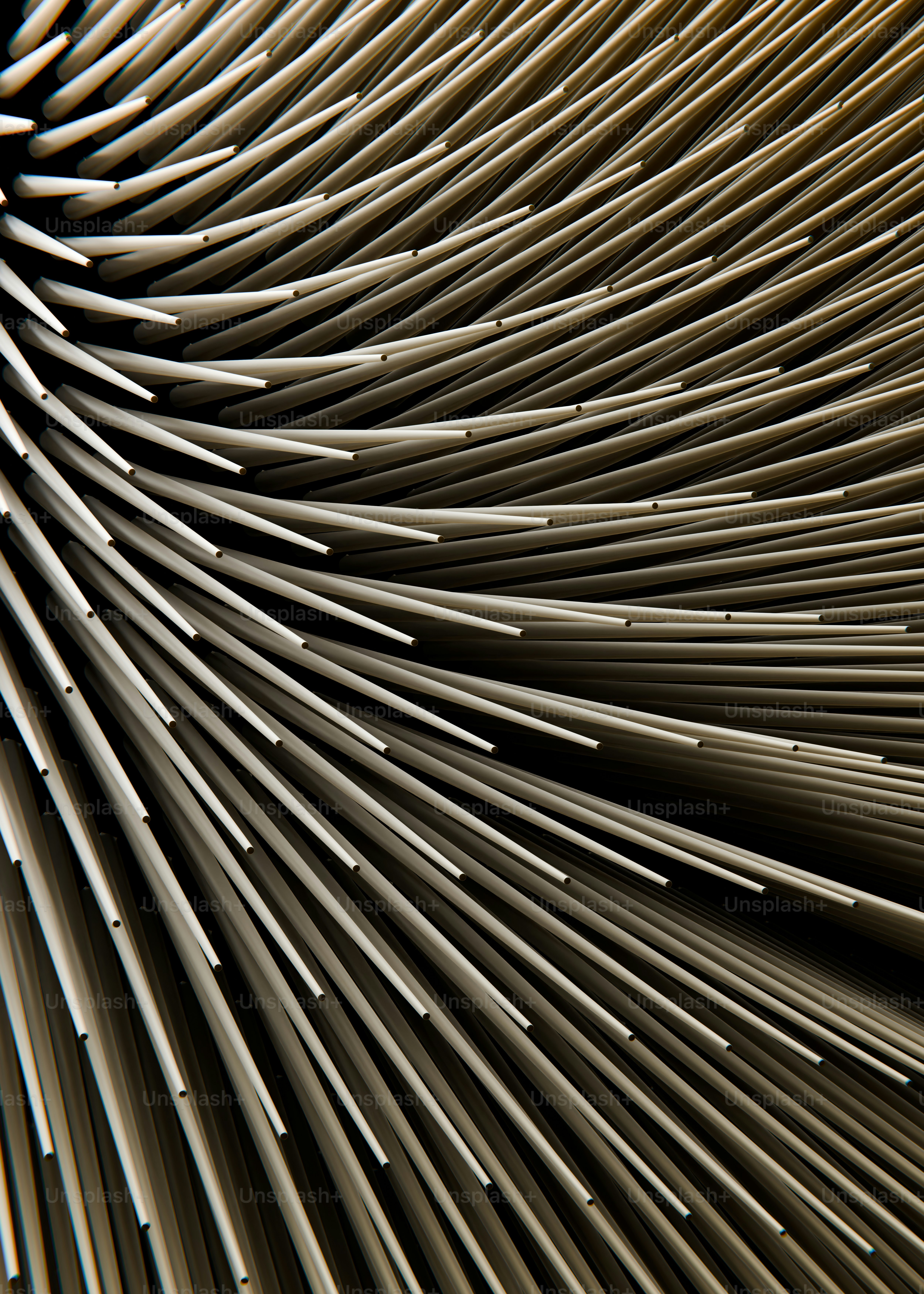 A dense pattern of thin white plastic tubes curving against a dark background