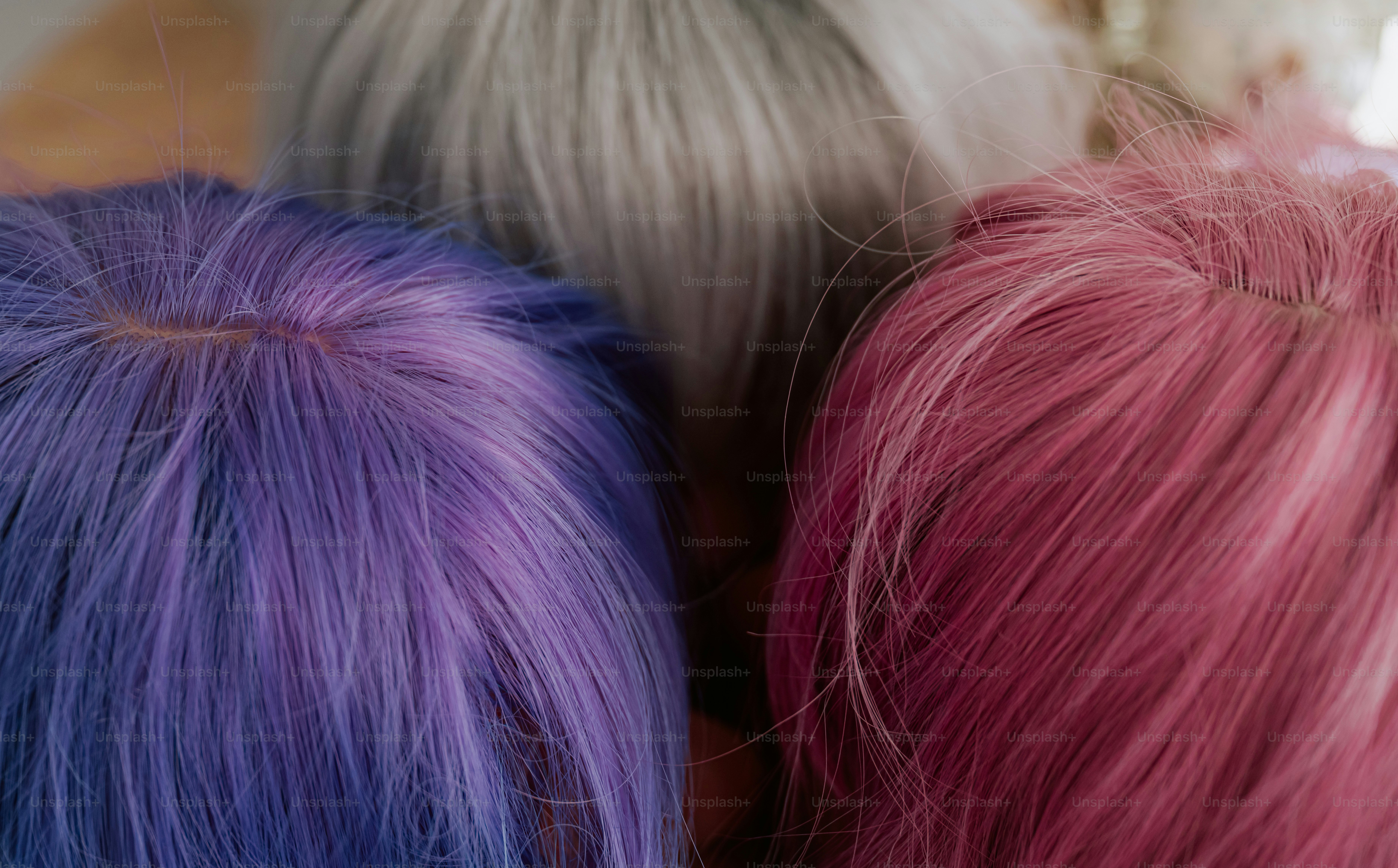 Three people with dyed purple, silver, and pink hair seen from above