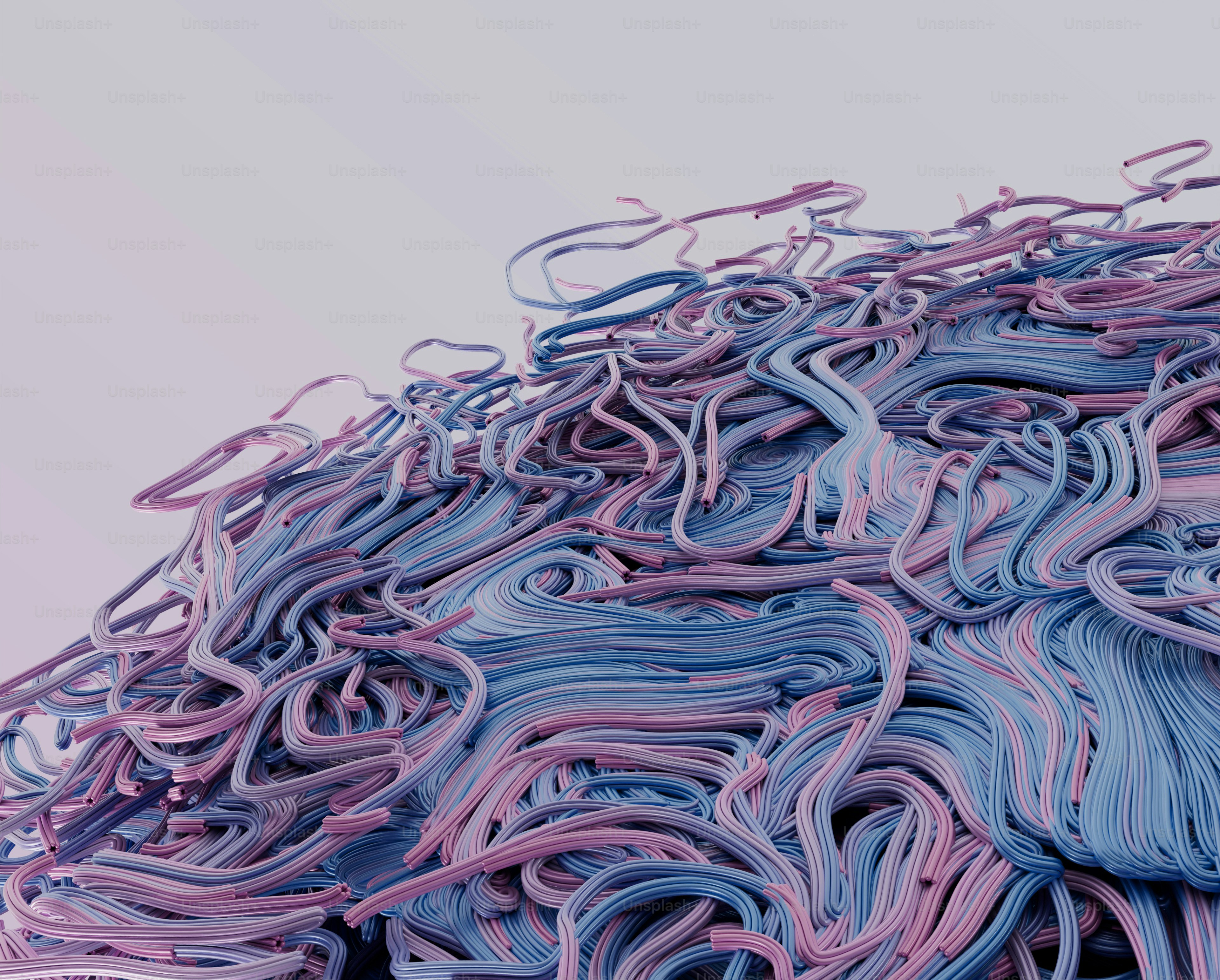 A tangled mass of blue and pink cables against a light grey background
