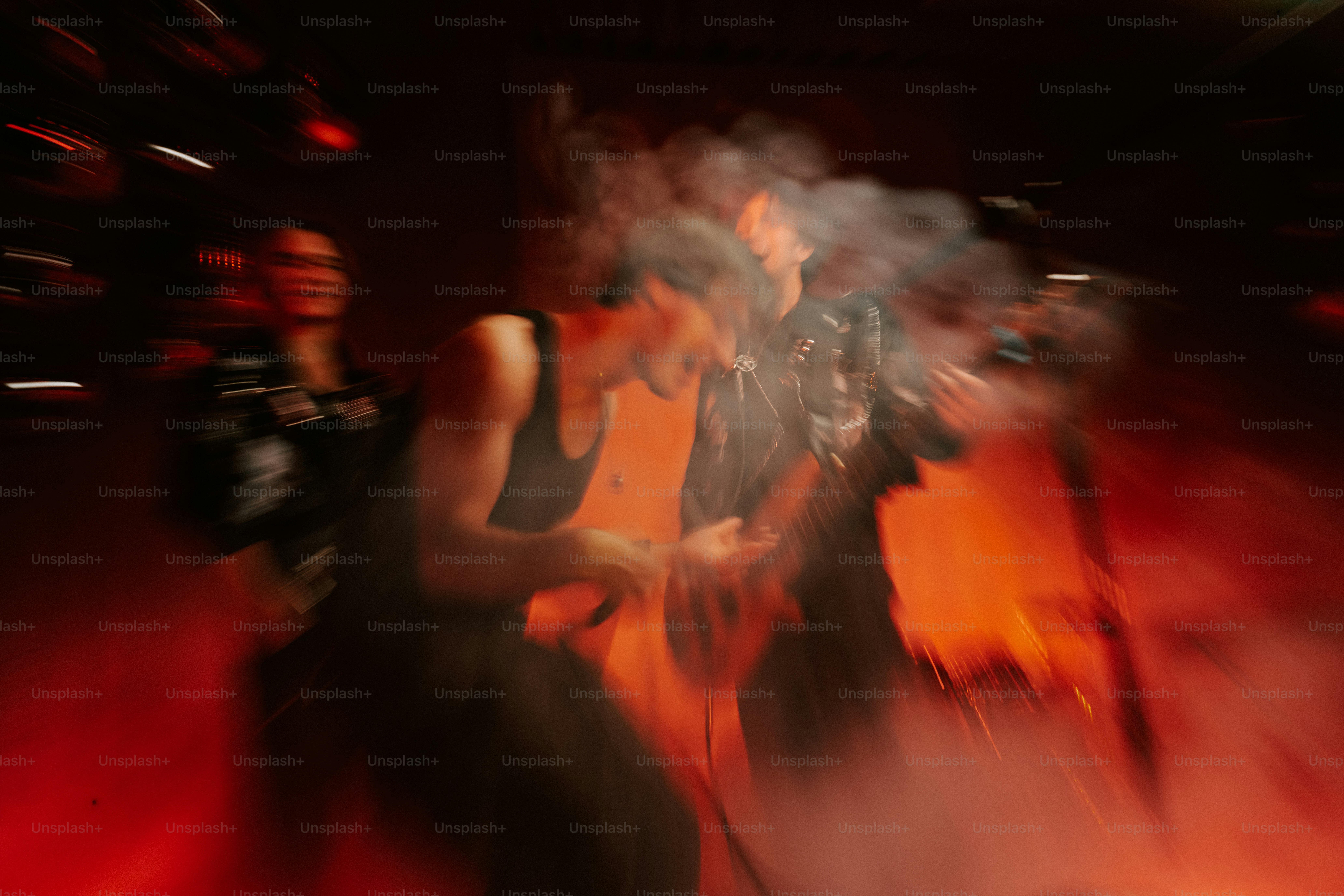 A band performing on a stage with motion blur and thick red smoke