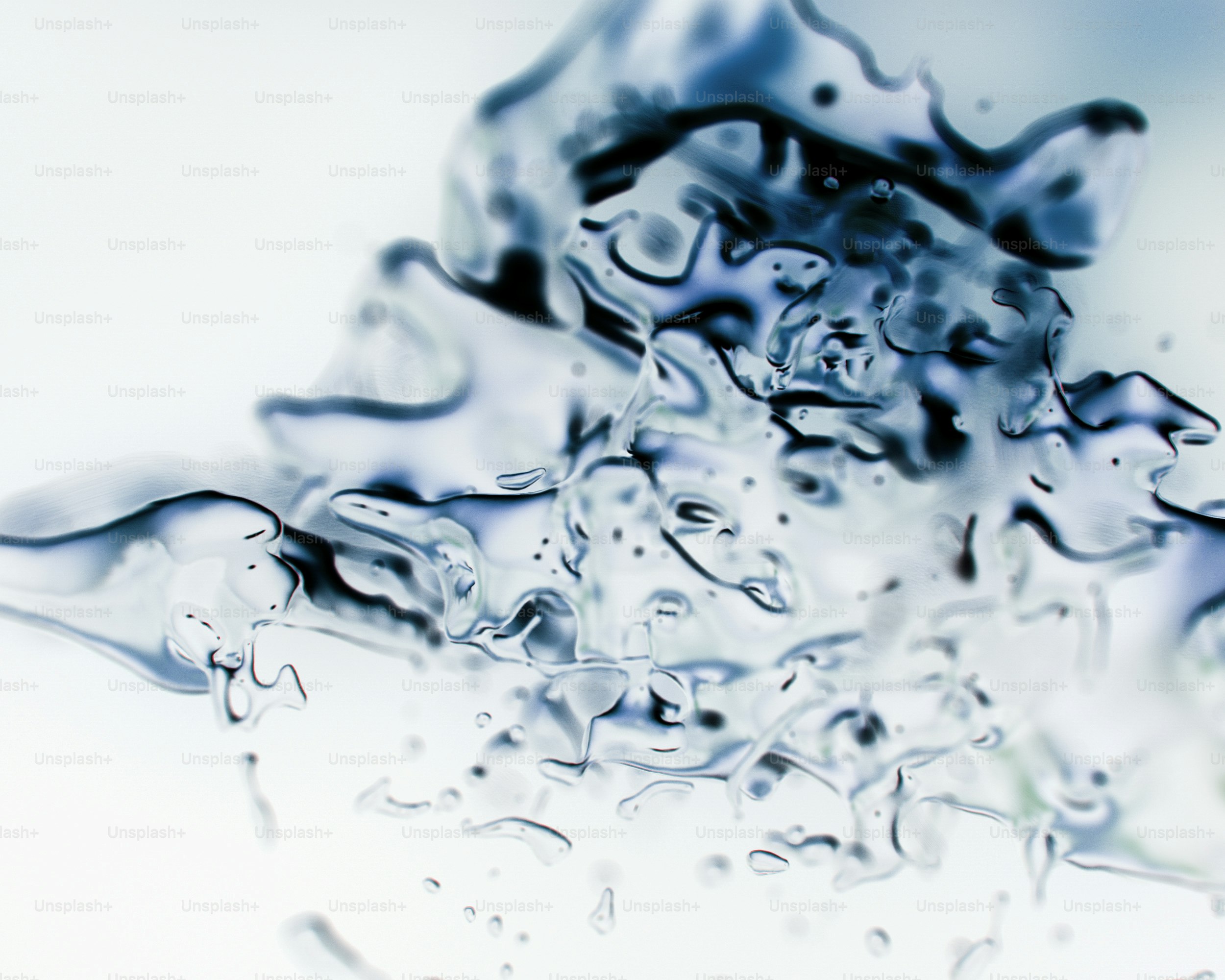 Ein Spritzer klarer Flüssigkeit mit blauen Akzenten vor weißem Hintergrund