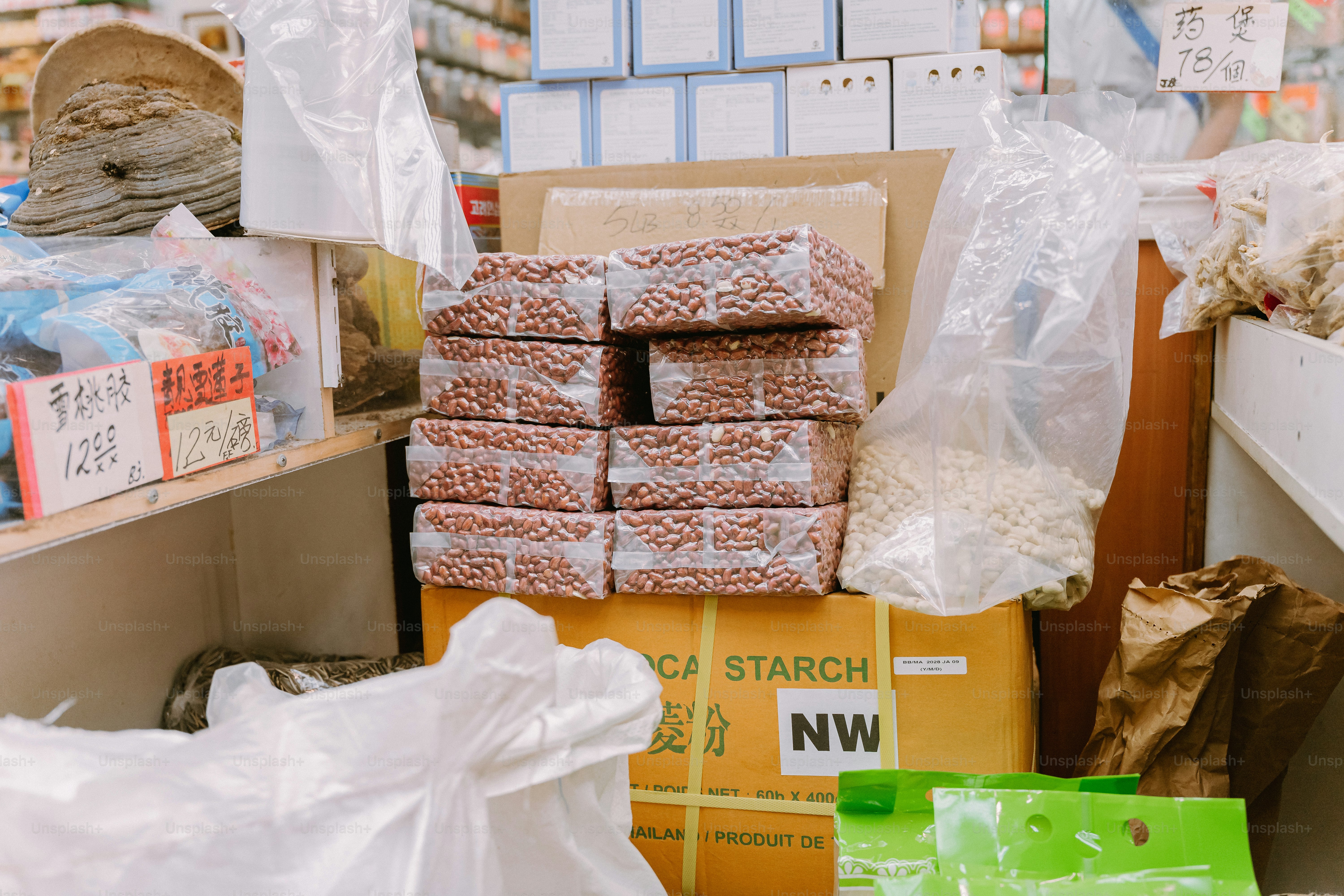 Stacked rectangular packages of raw peanuts in plastic wrap on a cardboard box