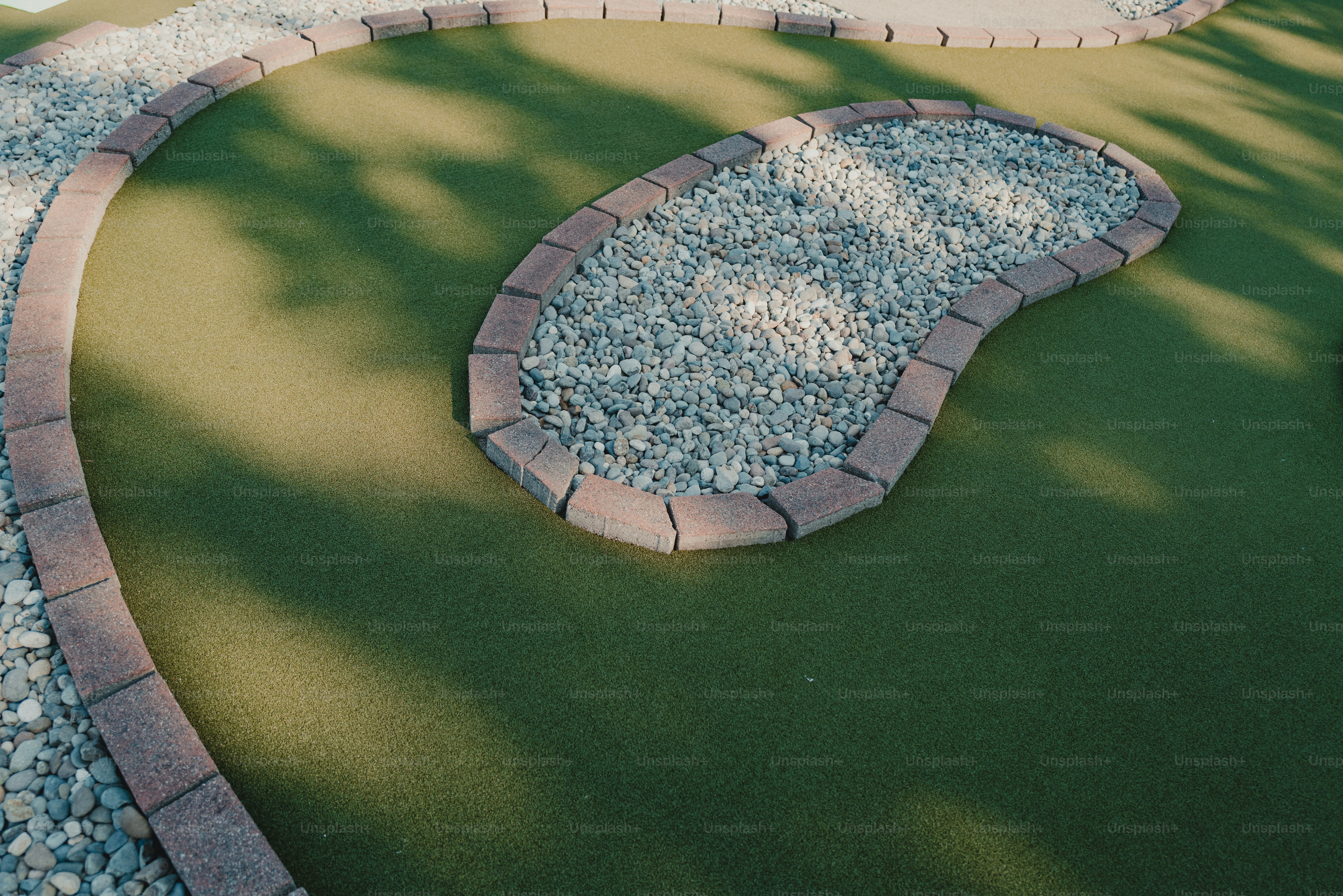 Ein Minigolfplatz mit grünem Rasen und einem Steinkiesel-Hindernis
