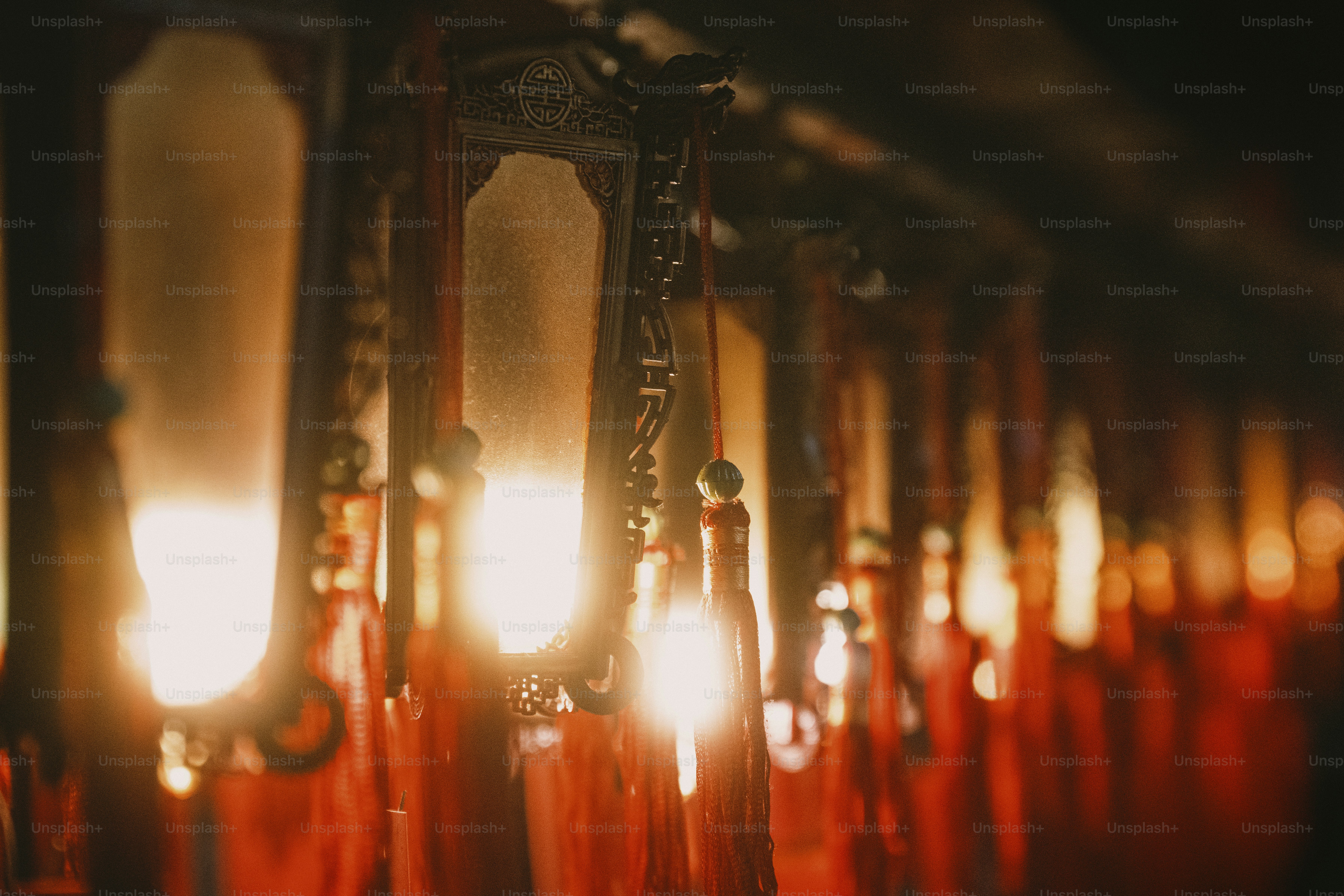 Uma fileira de lanternas tradicionais ornamentadas com luz brilhante e borlas vermelhas