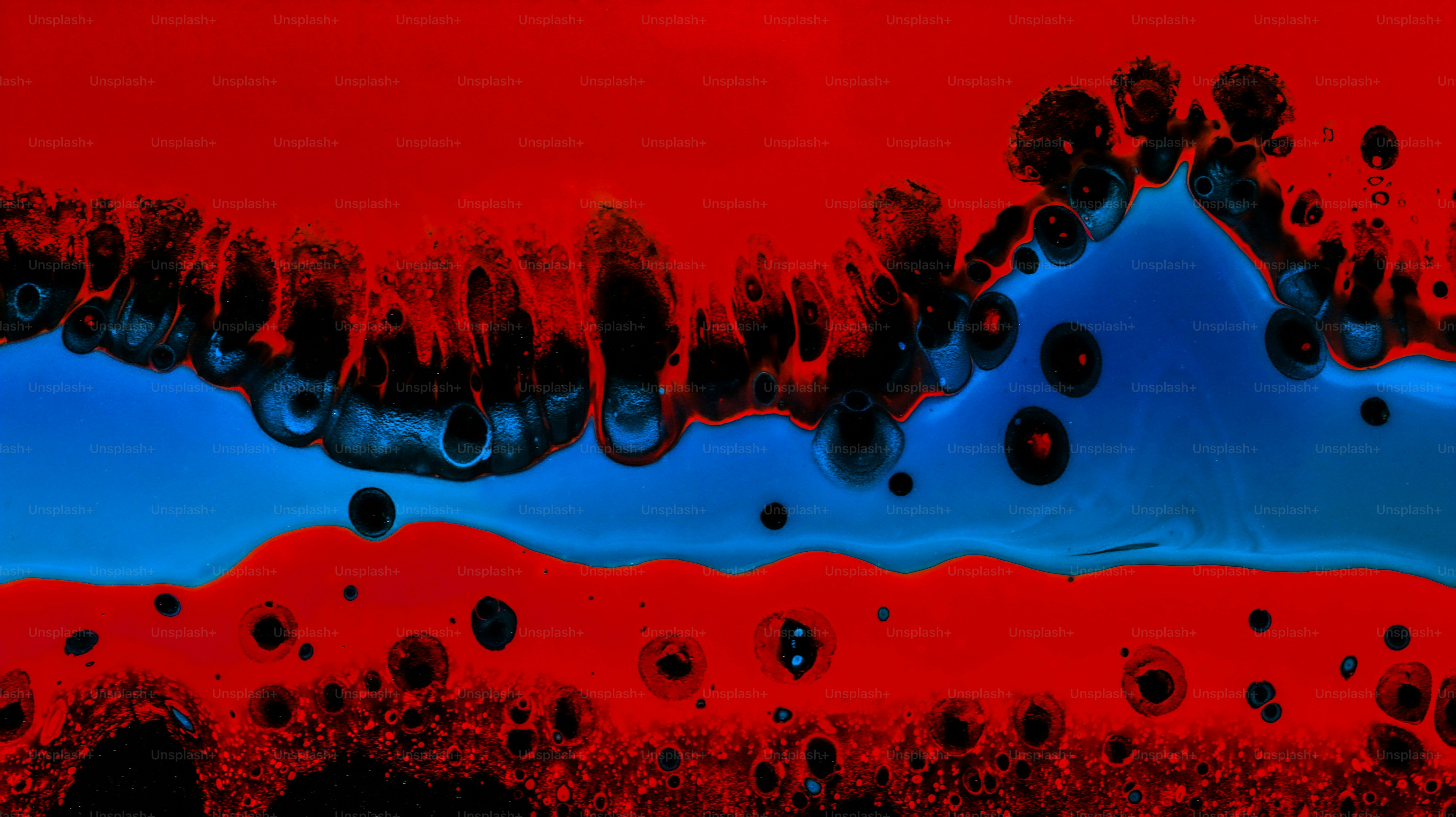 Abstract swirls of vibrant red and blue paint with black circular cells
