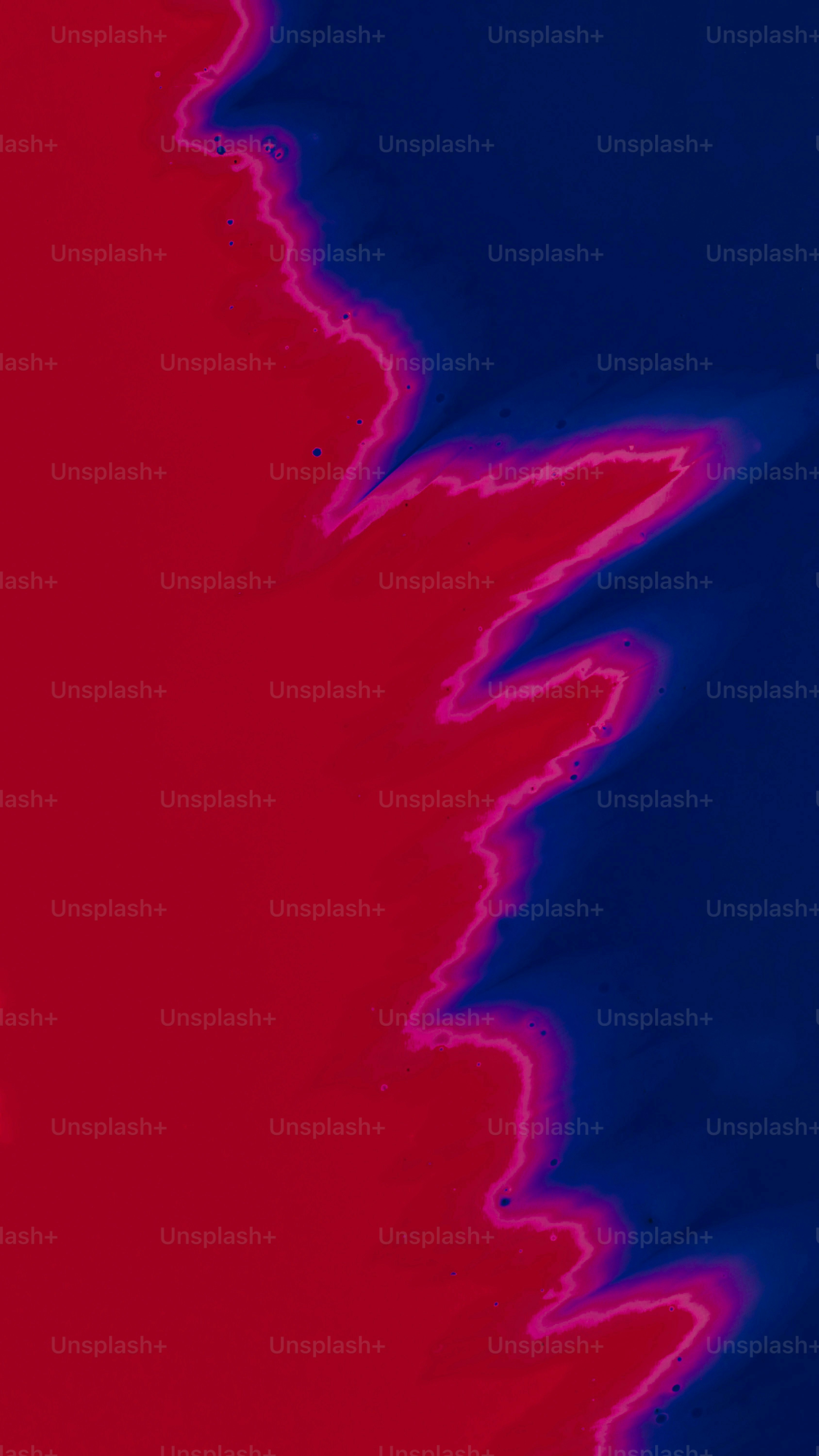 A vibrant abstract pattern with a jagged transition between deep red and blue
