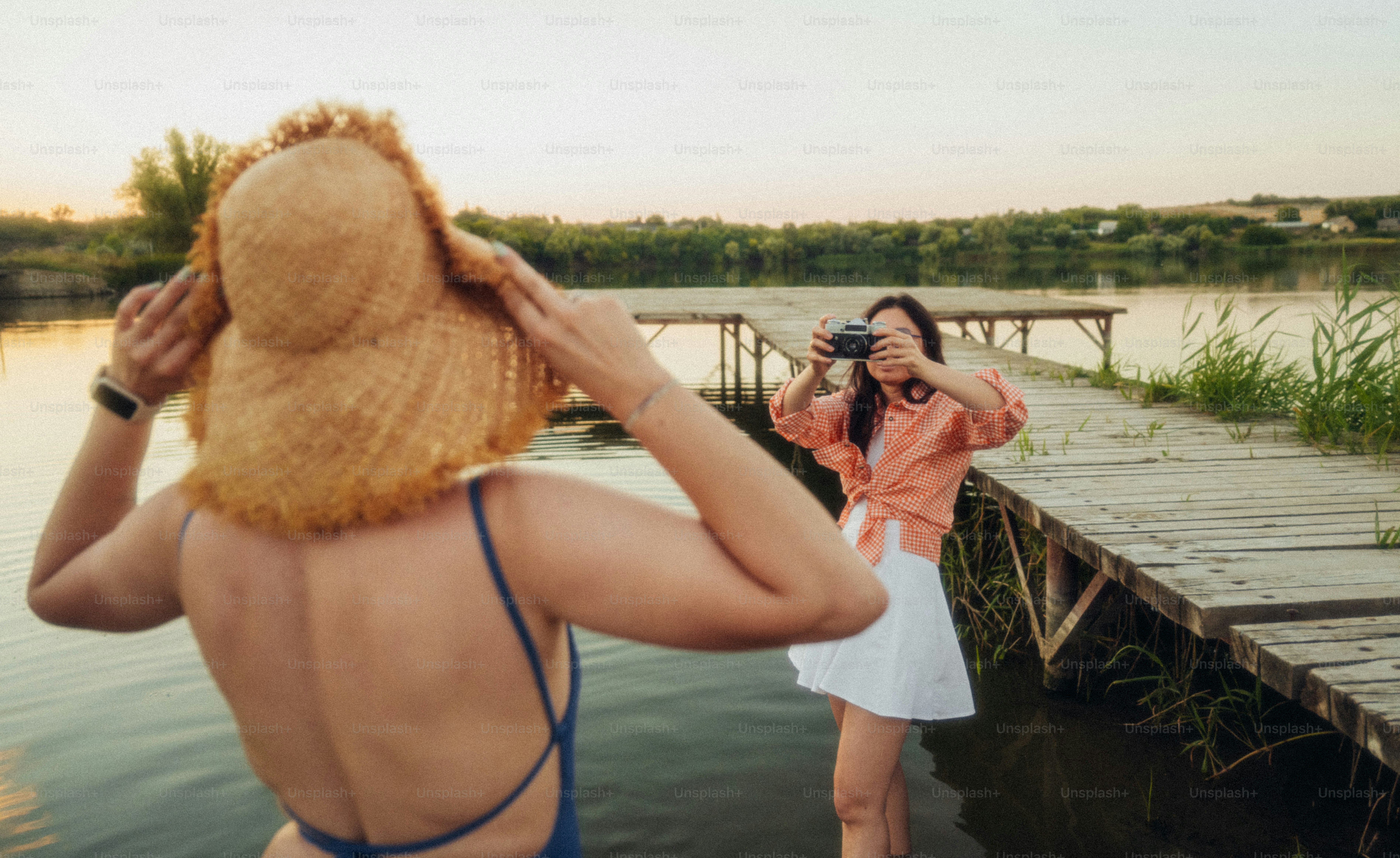 A woman in a straw hat posing for a photo on a wooden pier