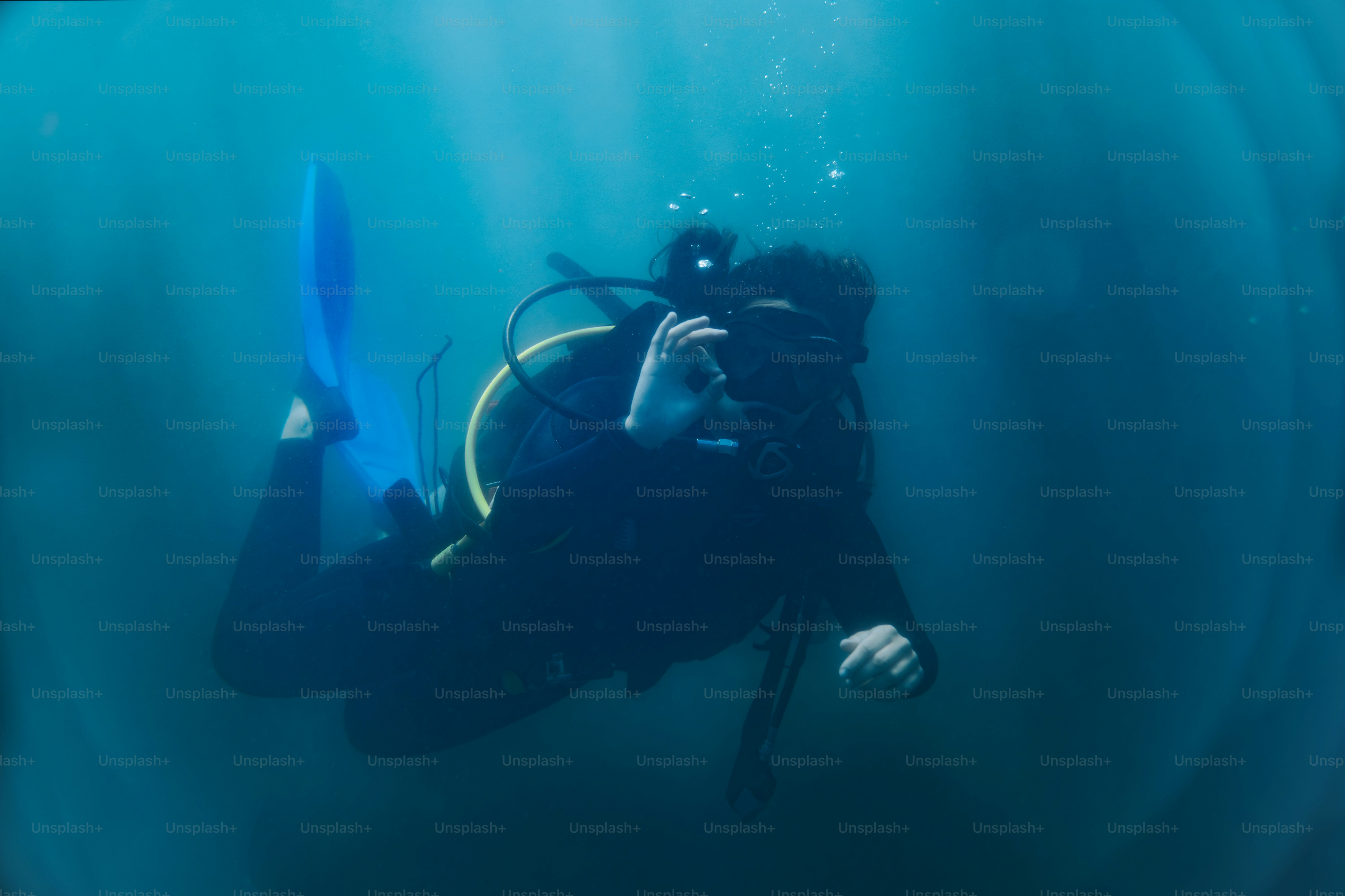Scuba diver floating in ocean - Photo on Unsplash+