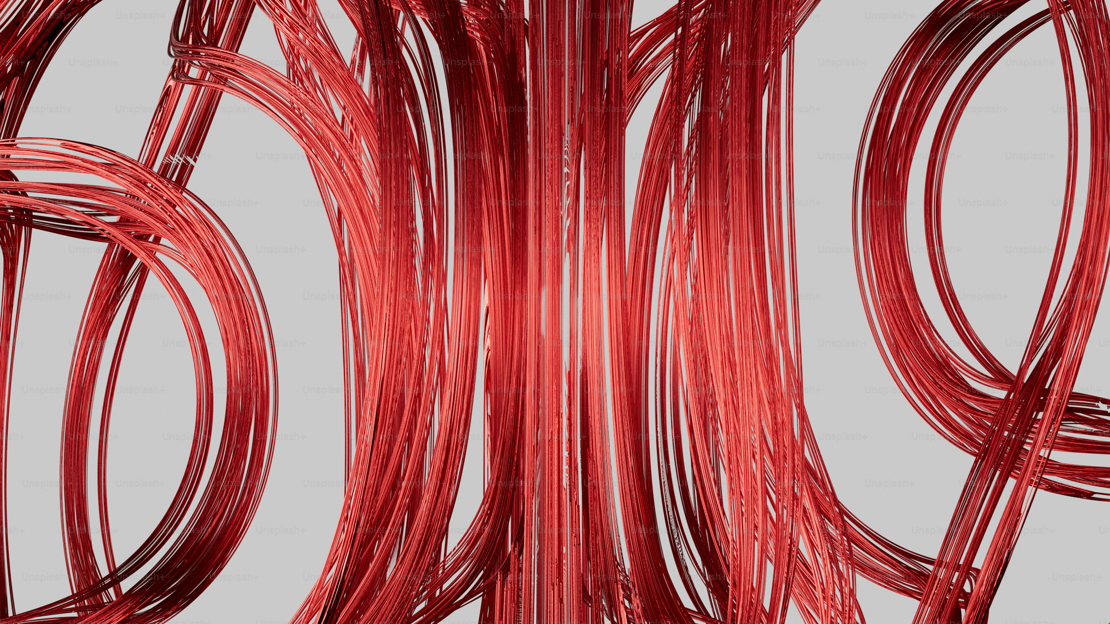 Abstract red metallic wires curving and looping against a light grey background