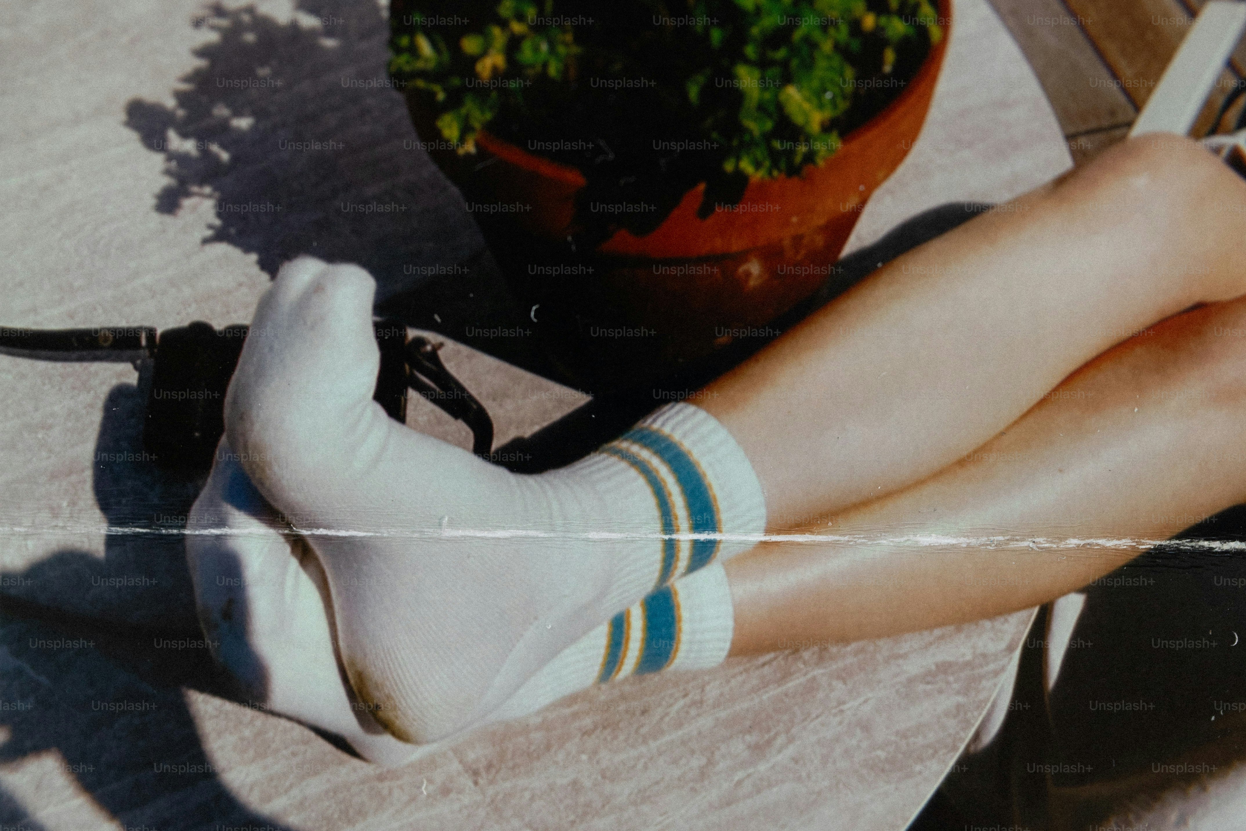 A person wearing white socks with blue and yellow stripes on a table