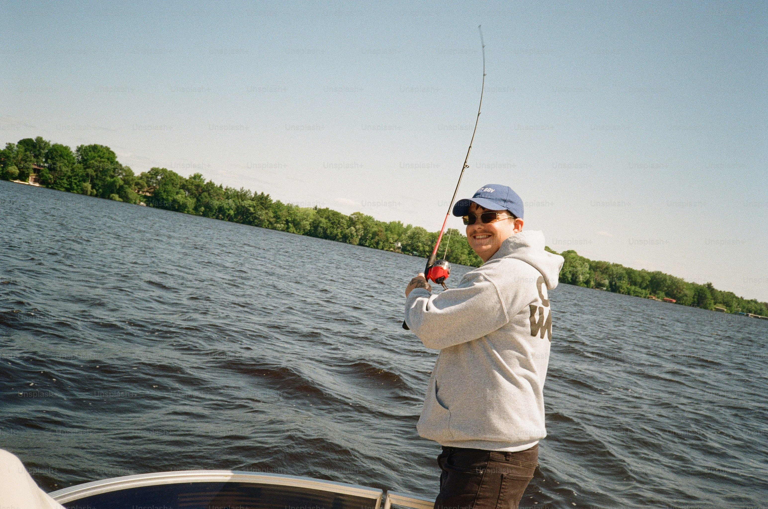 Eine Person mit grauem Hoodie und blauer Mütze angelt am Lake Wisconsin