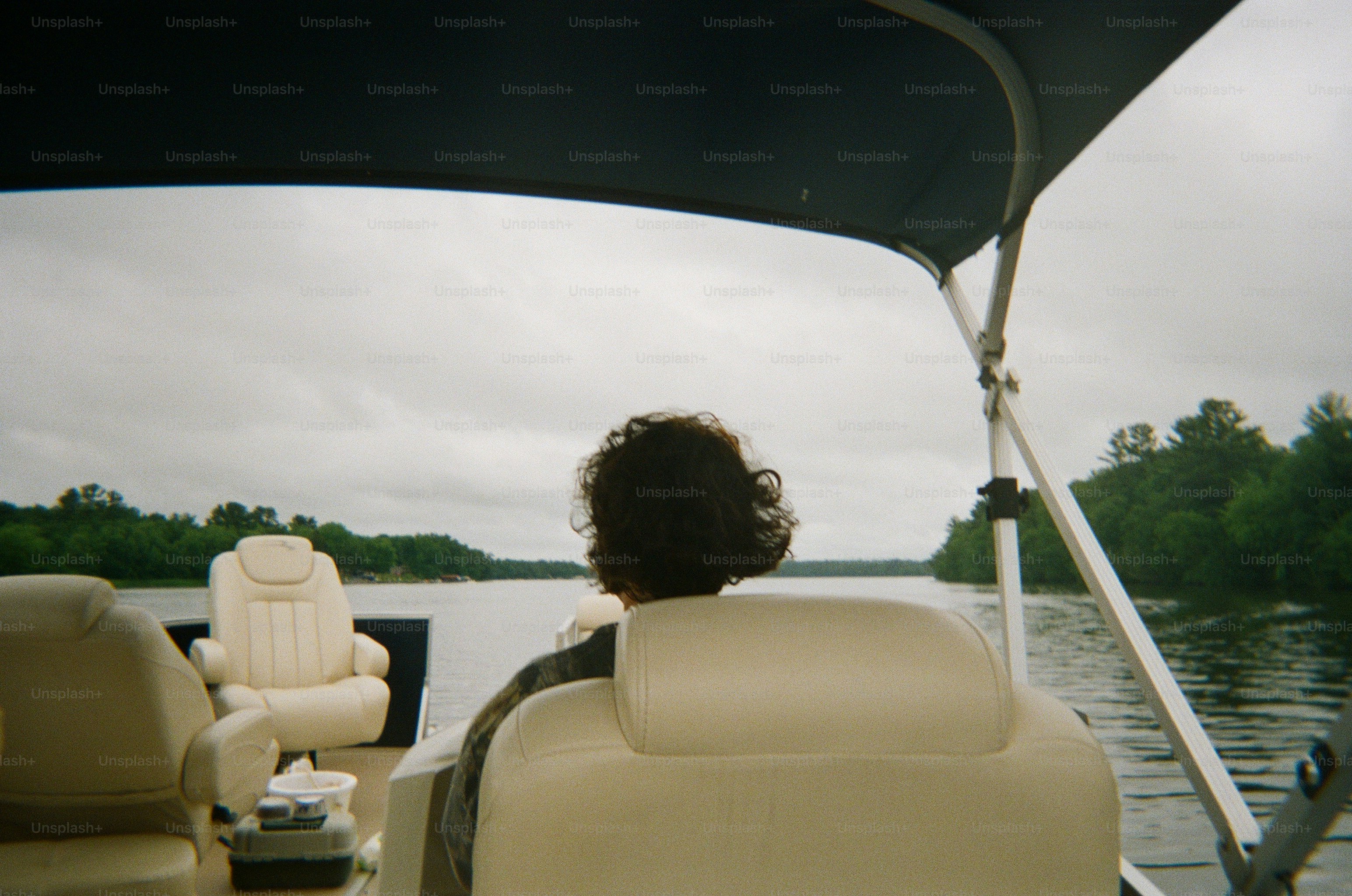 Eine Person mit lockigen Haaren in einem weißen Bootssitz auf dem Lake Wissota