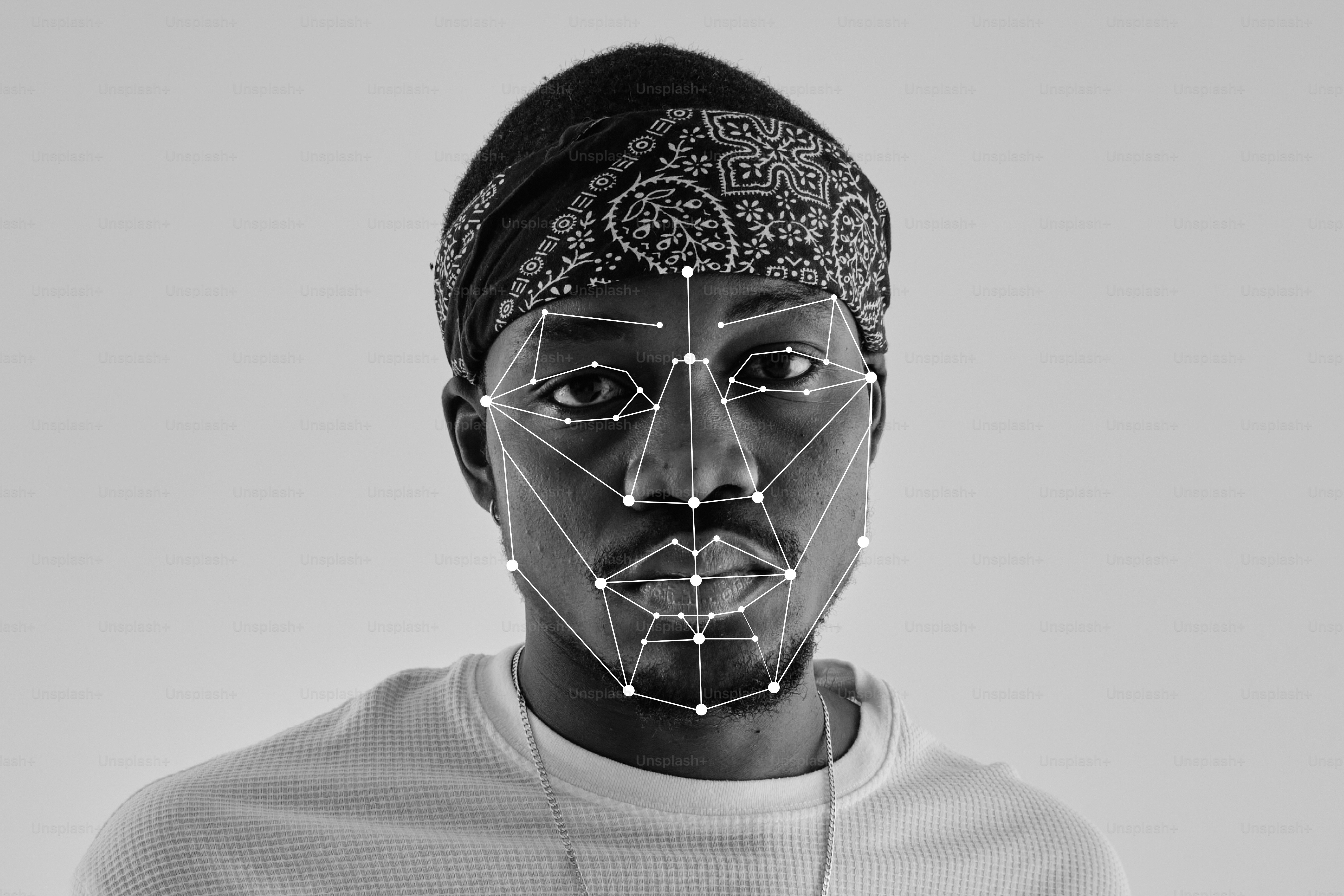 A person wearing a bandana with a digital facial recognition mesh overlay