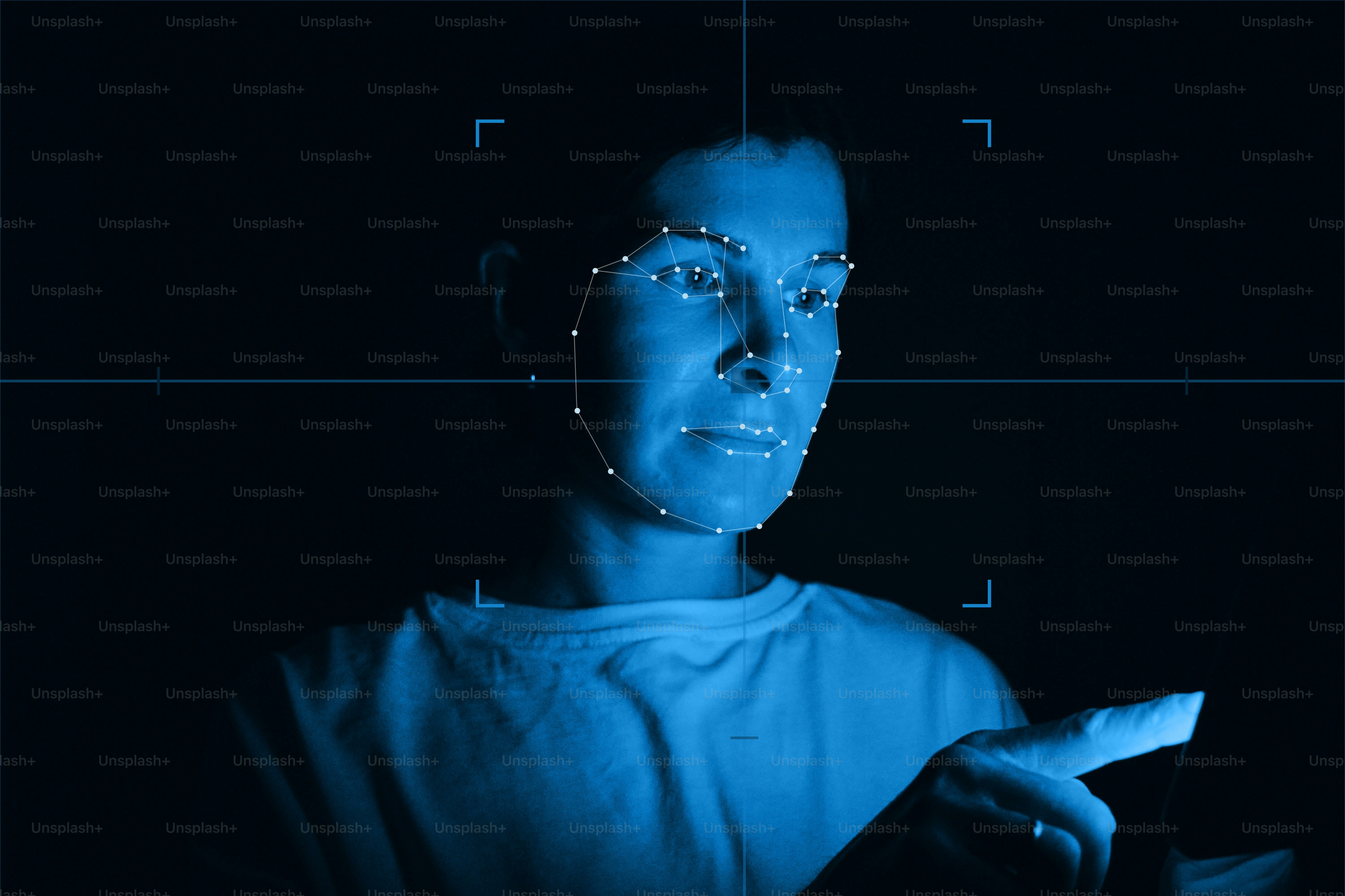 A person with a digital facial recognition mesh overlay in blue light