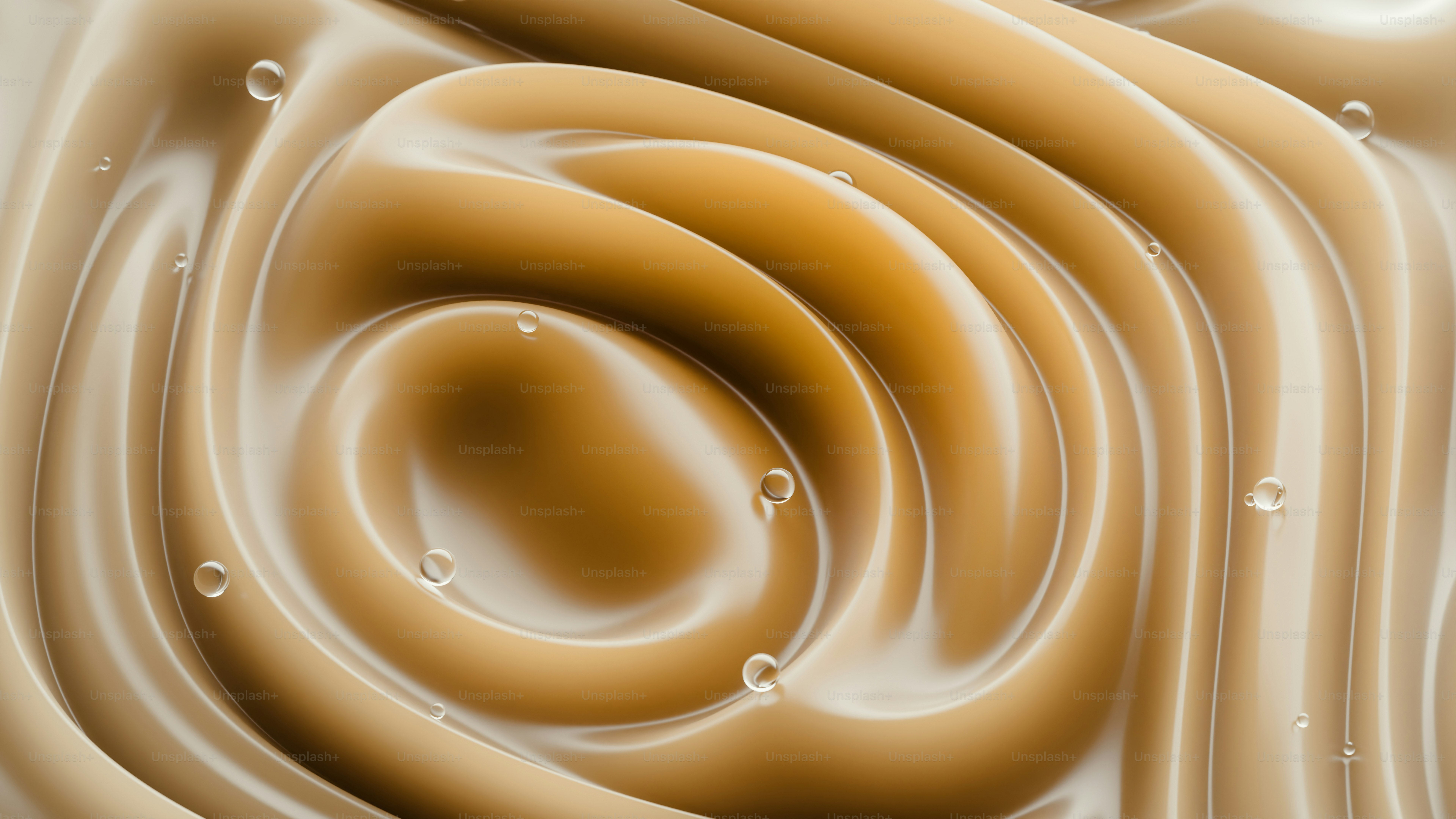 Smooth beige liquid swirls with small clear water droplets on the surface