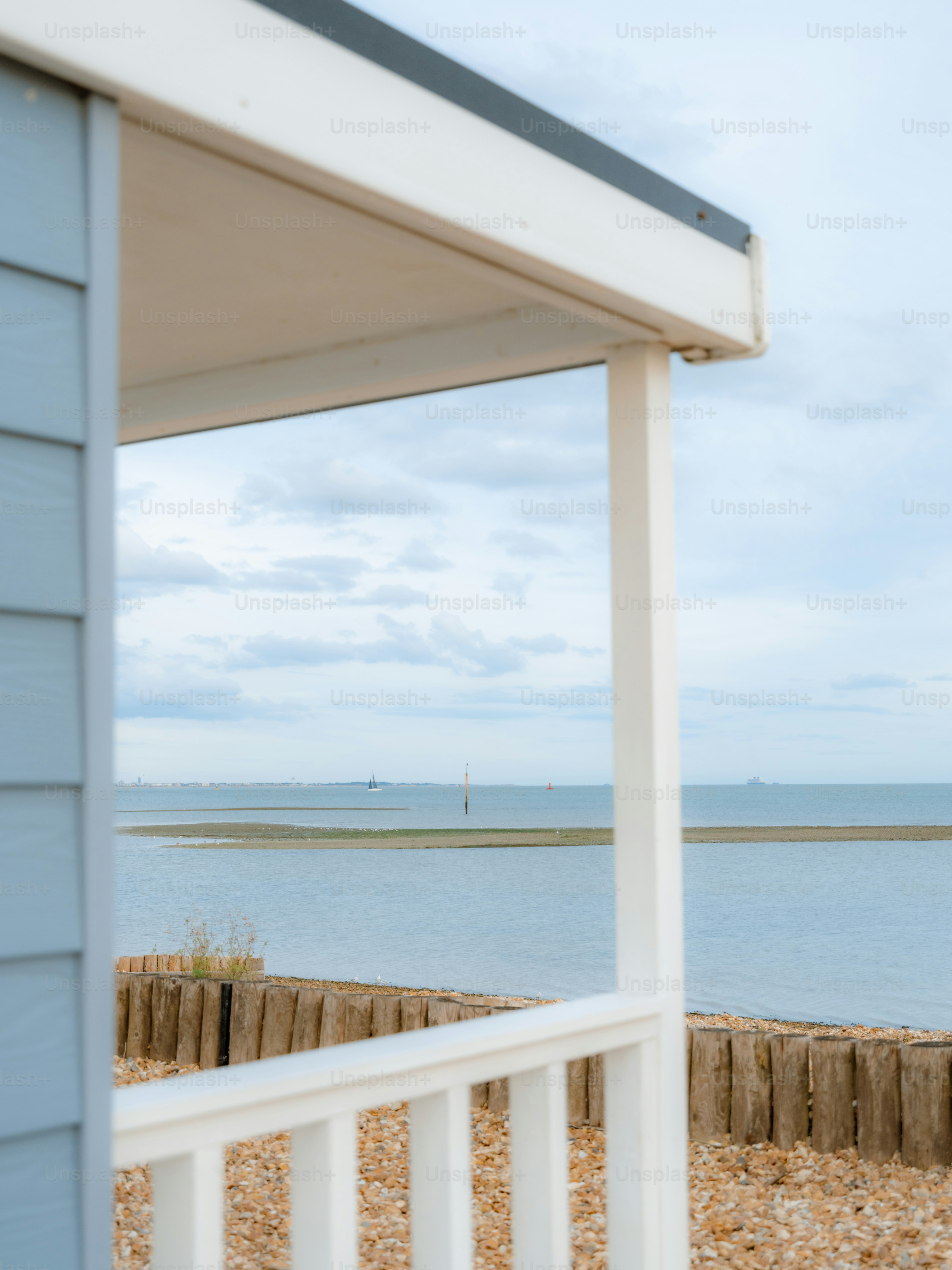 A view of the sea and a sandbar from a wooden porch
