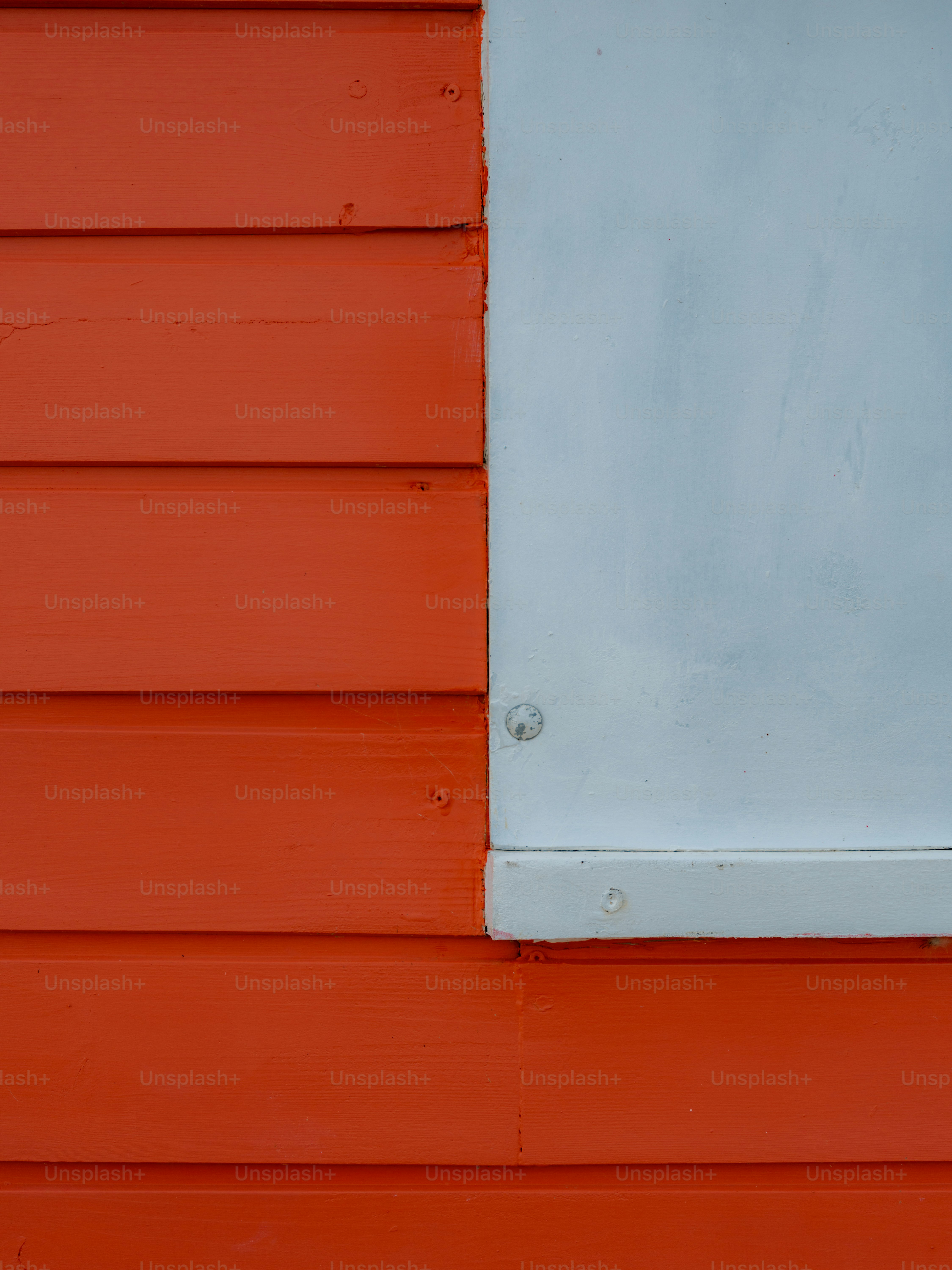 Horizontal orange wooden planks beside a smooth light grey panel