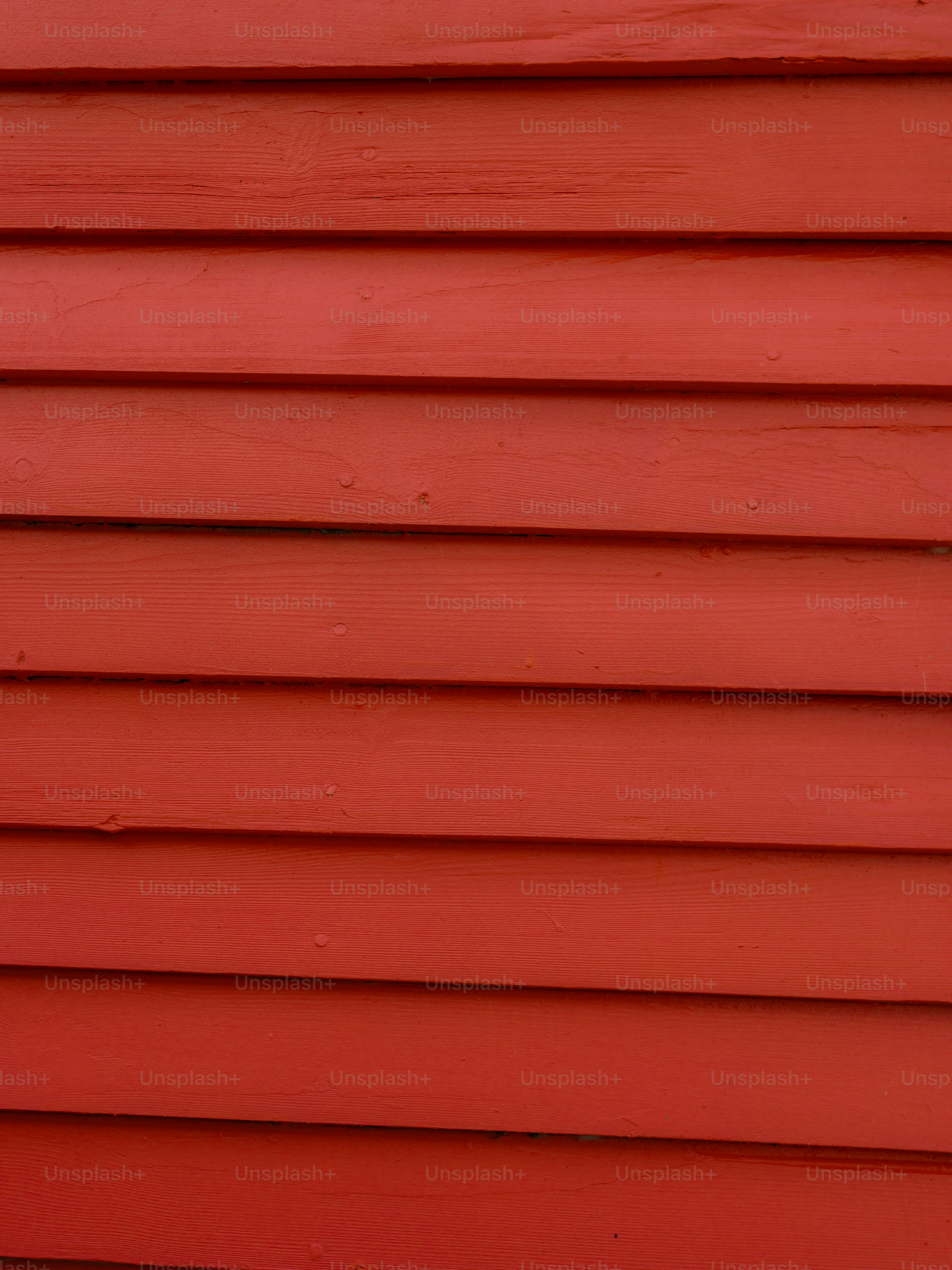 Horizontal red wooden planks with visible grain and overlapping edges
