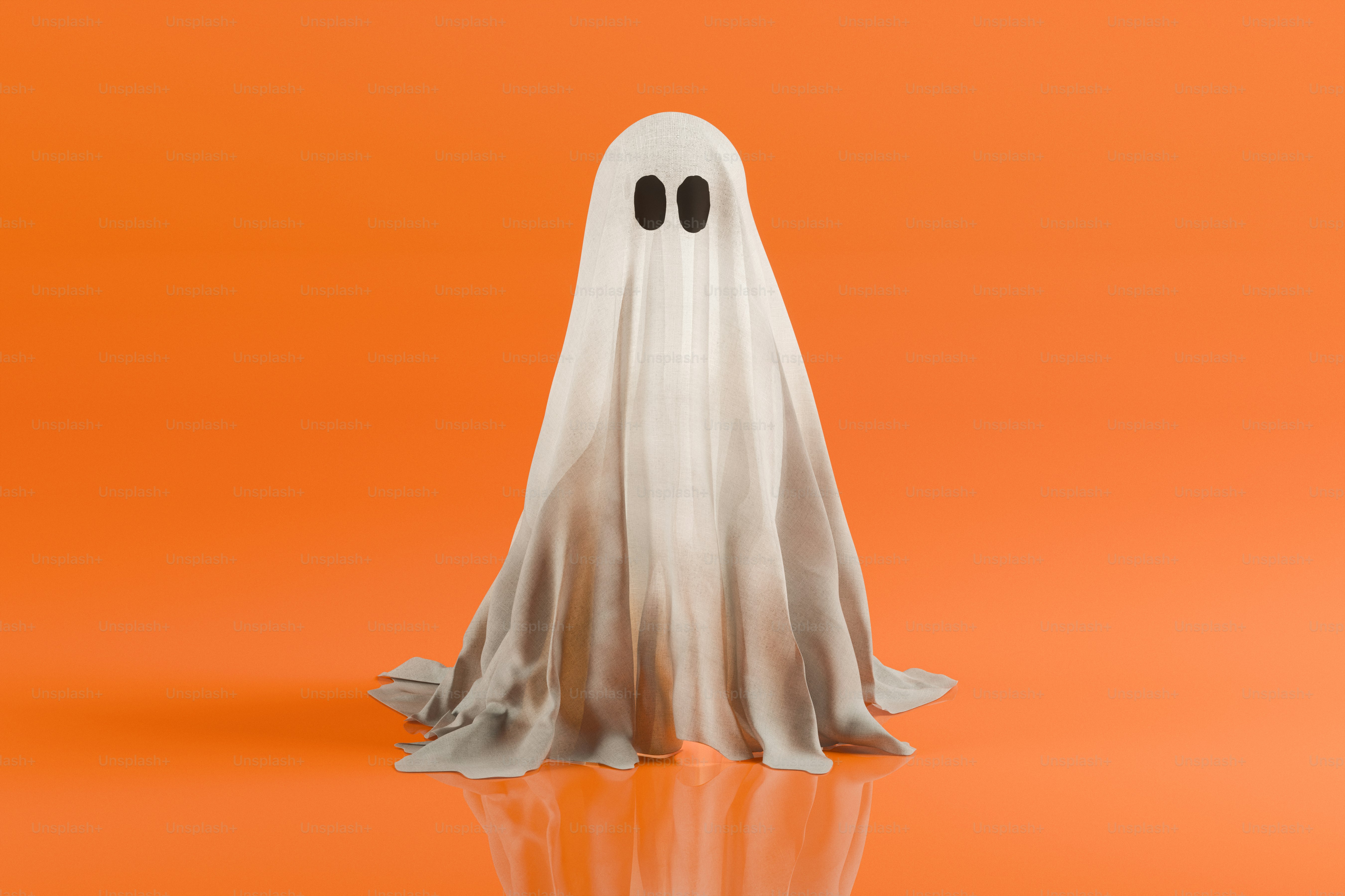 A white sheet ghost with black oval eyes on an orange background