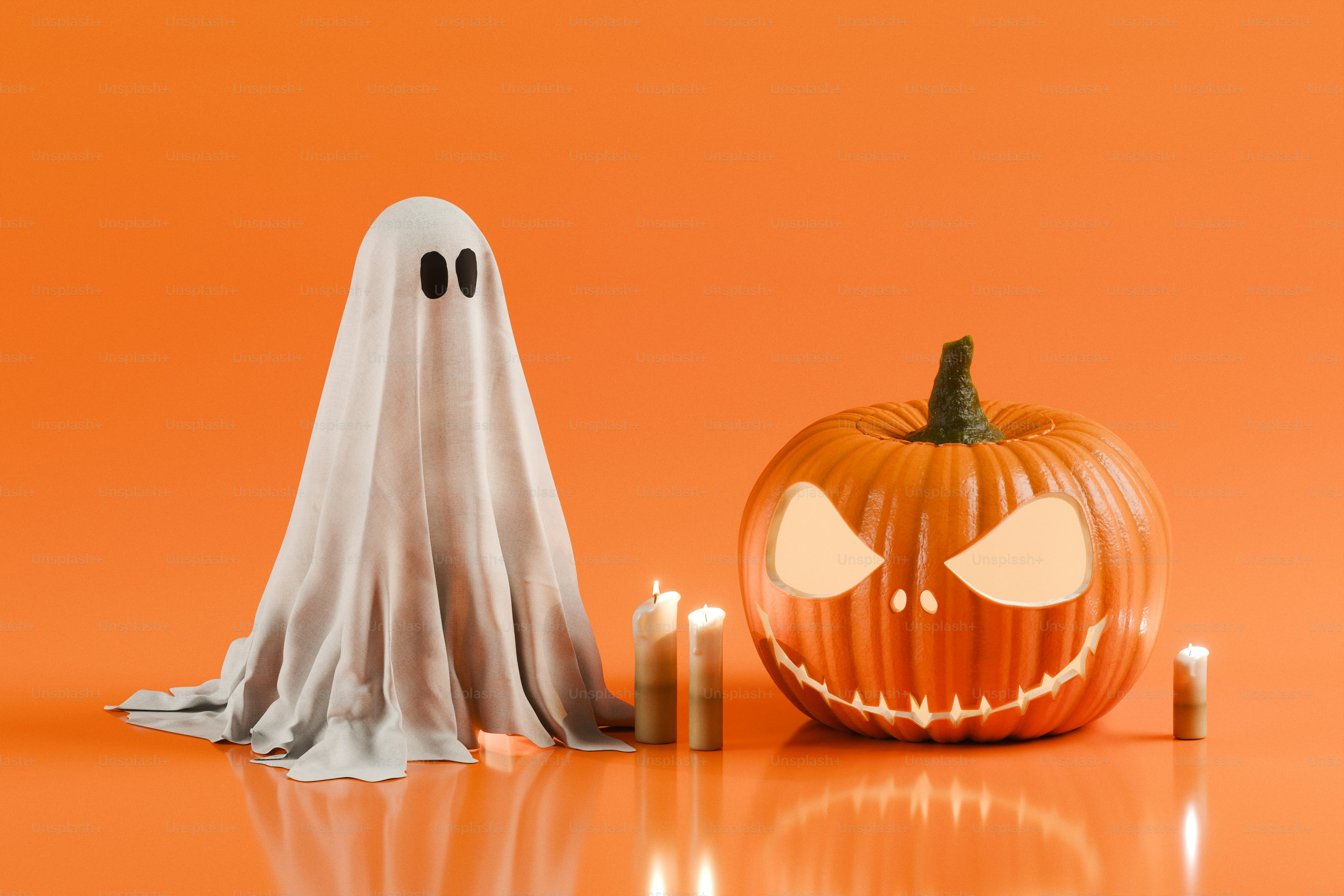 A white ghost costume beside a carved jack-o'-lantern and three lit candles
